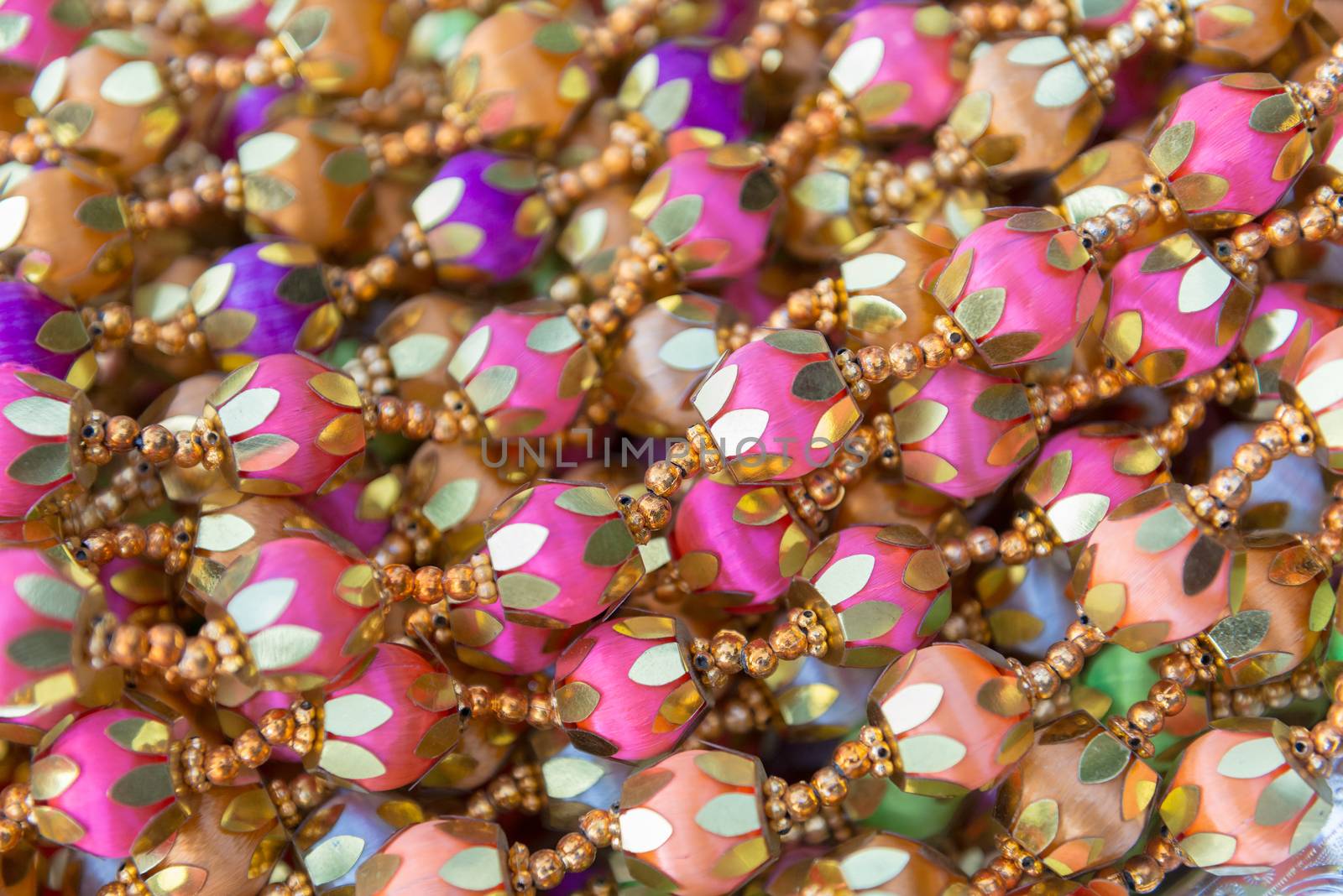 Indian traditional culture stuff from colourful beads pink violiet orange gold for holy religious ritual. Useful for background.