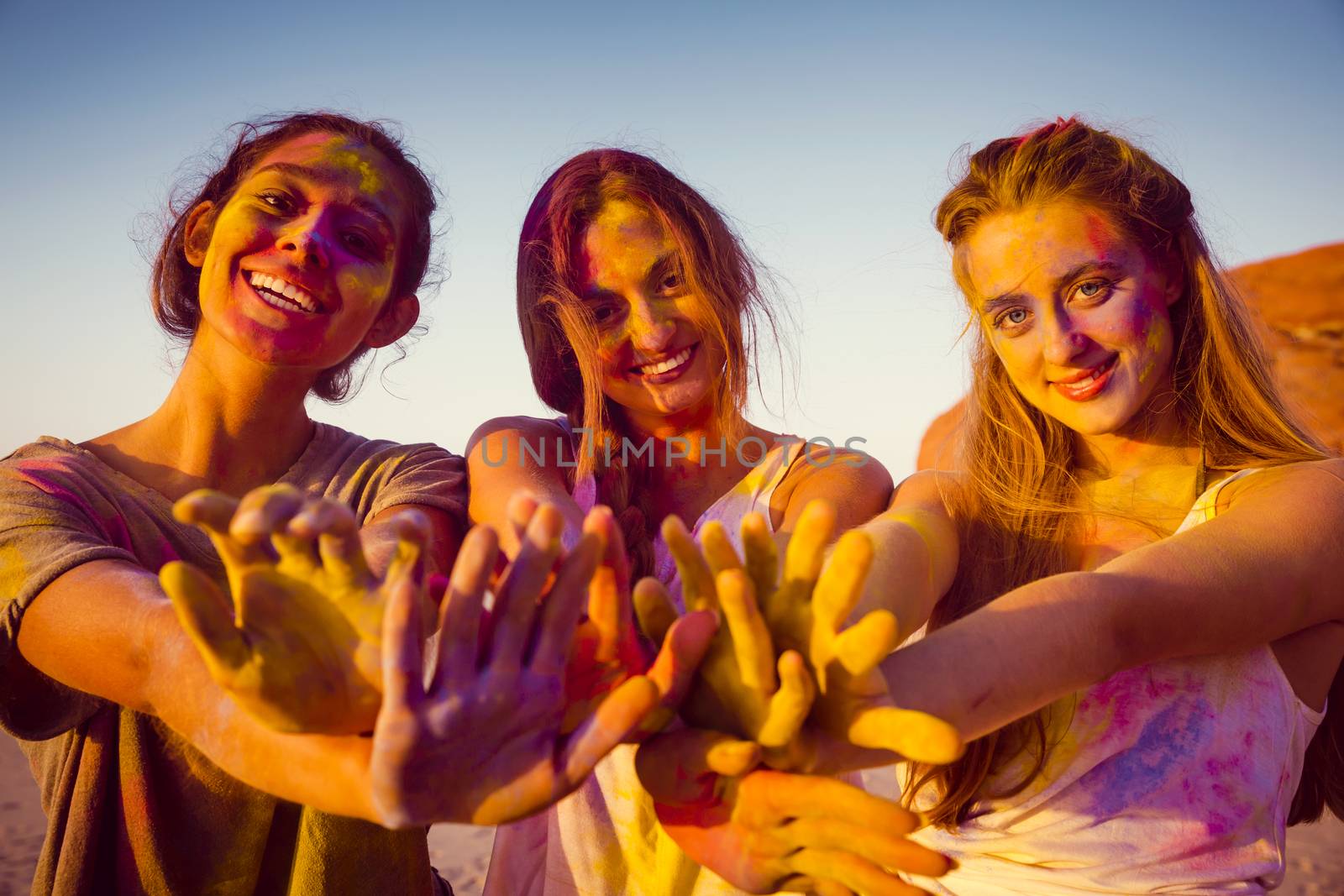 Teenagers playing with colored powder and showing her hands