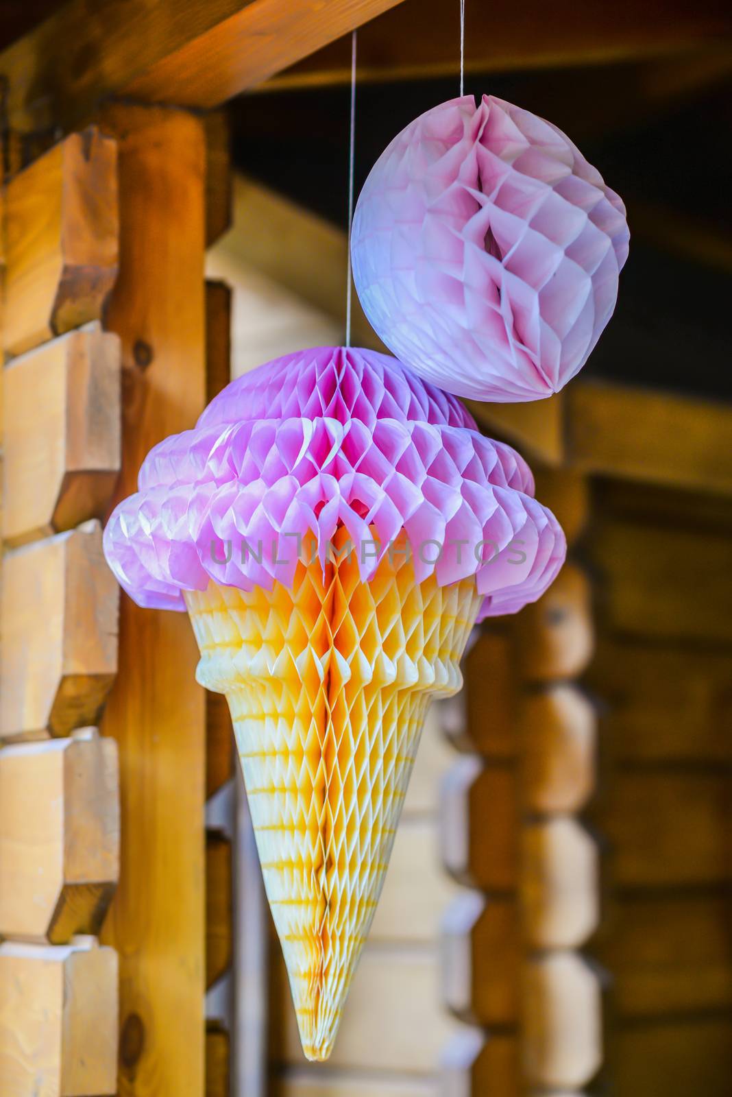pink paper ice cream hanging on a wooden girder
