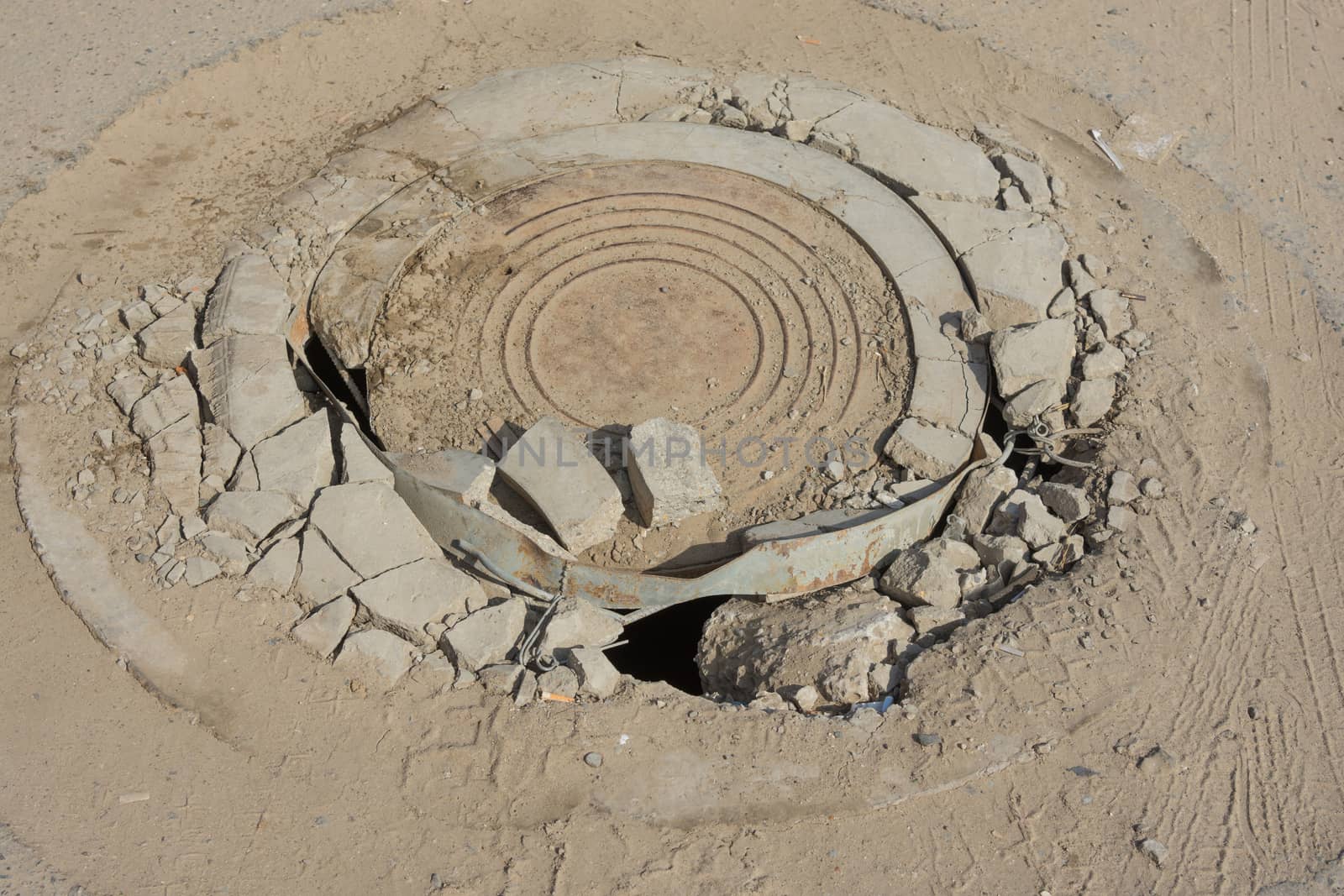 Destroyed well with cast iron lid on the dusty road