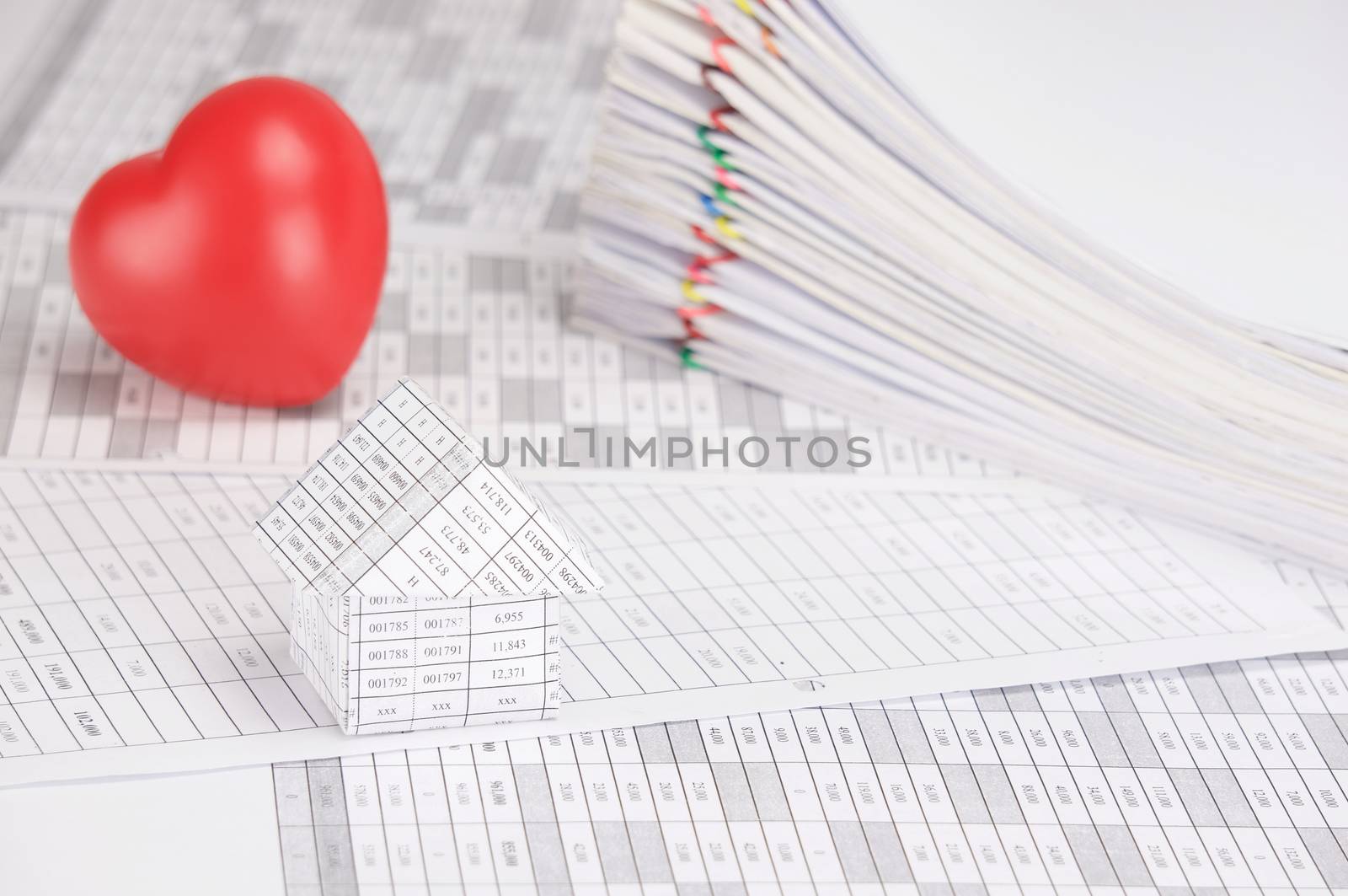 House on finance account have blur red heart and pile overload paperwork of receipt and report with colorful paperclip as background.