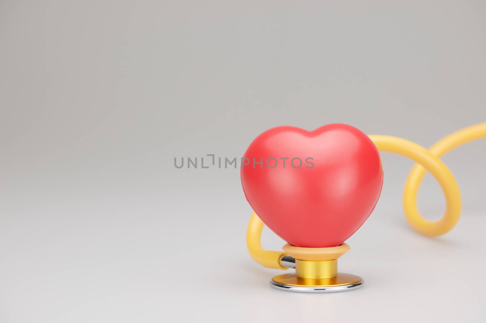 Red heart on stethoscope and swirl tube with white background by eaglesky