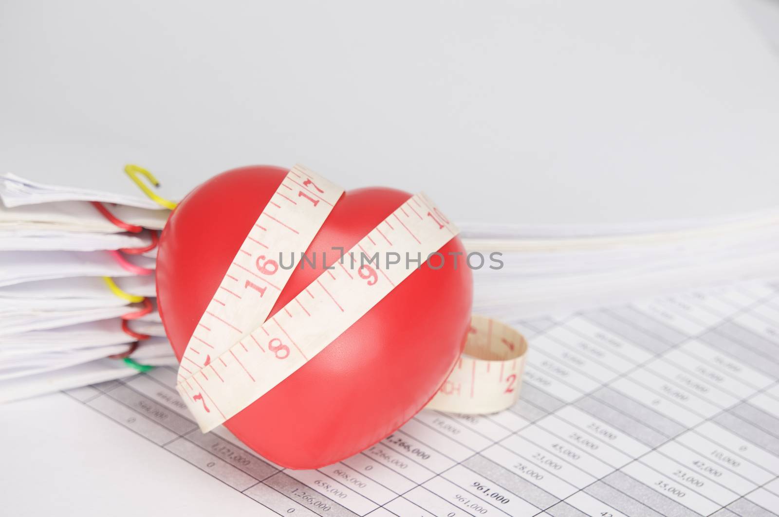 Red heart with measuring tape on finance account as background by eaglesky