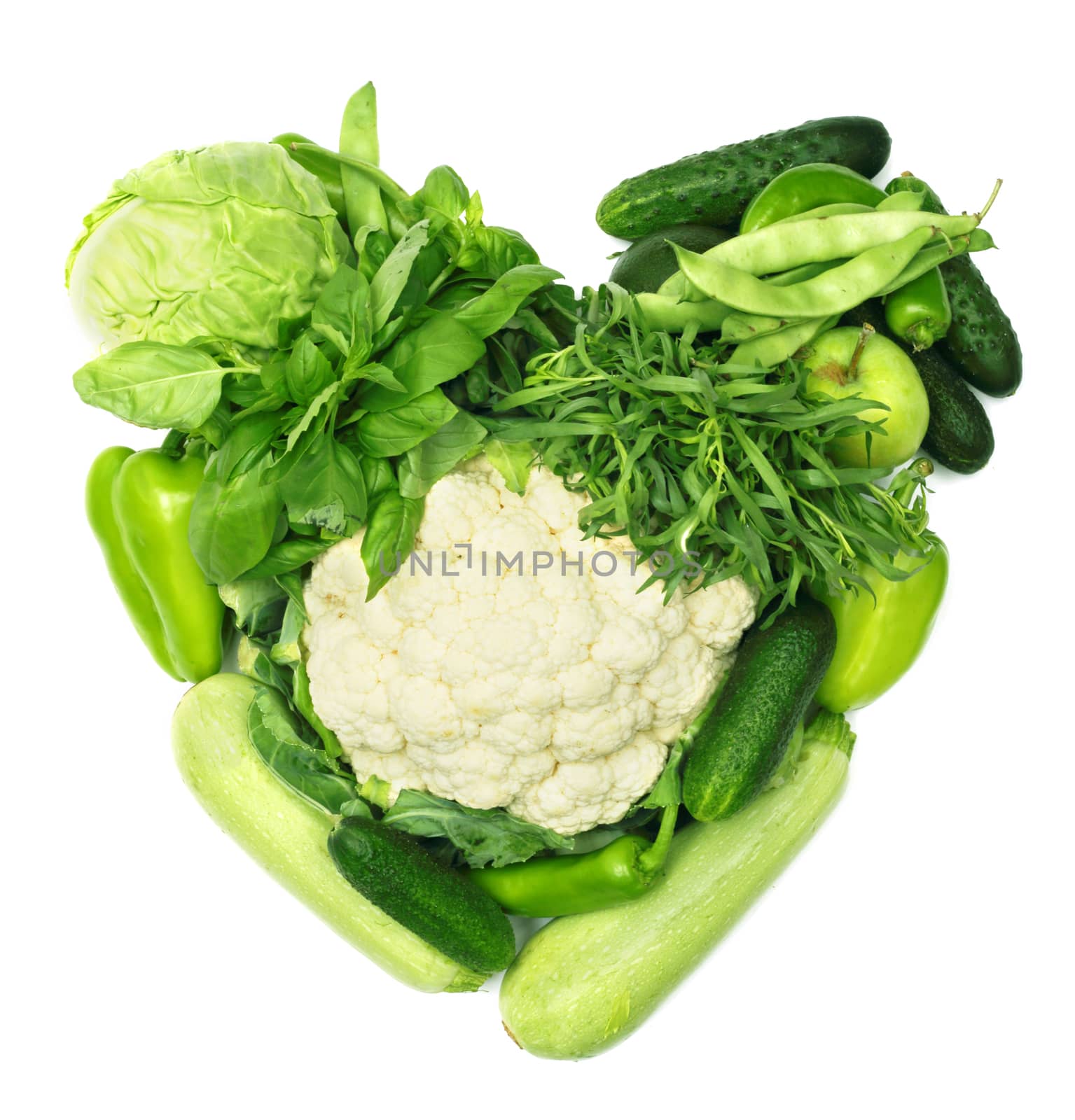 Pile of vegetables shaped as heart isolated on white background