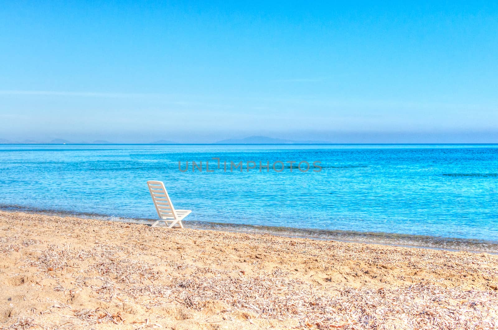 white chair on the beach in hdr by replica