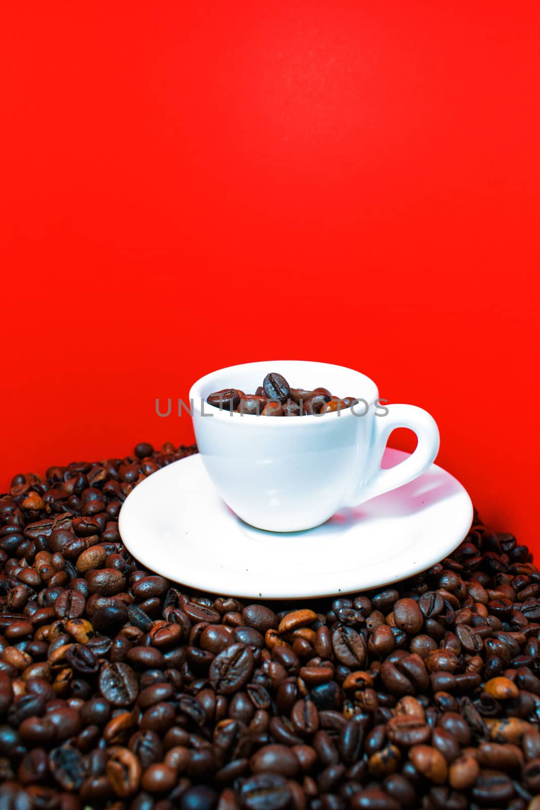 A coffee cup full of beans in a red background