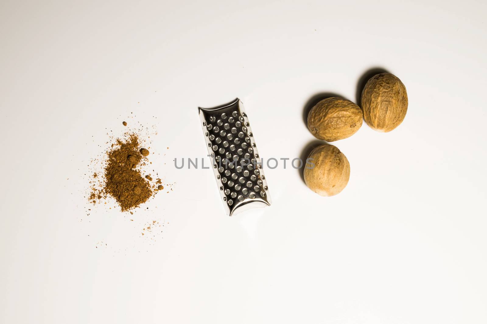 Nutmeg nut and powder in a white background