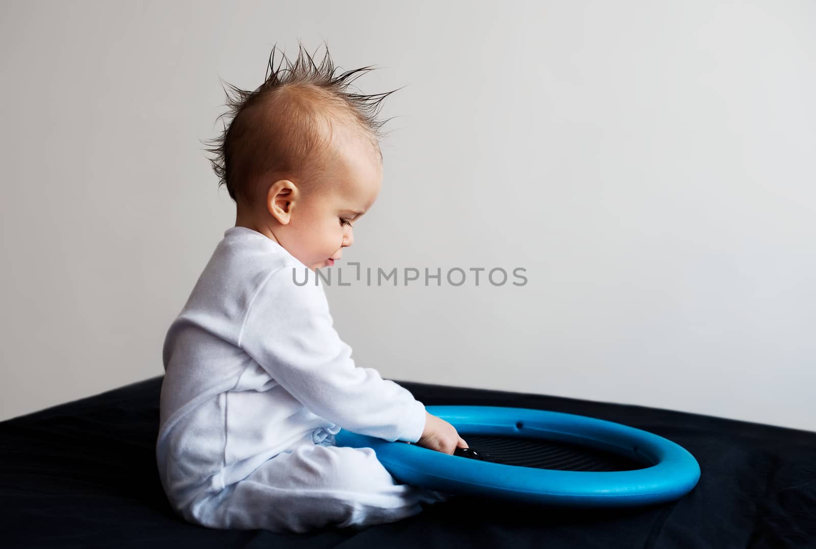 Baby with mohawk sitting and playing
