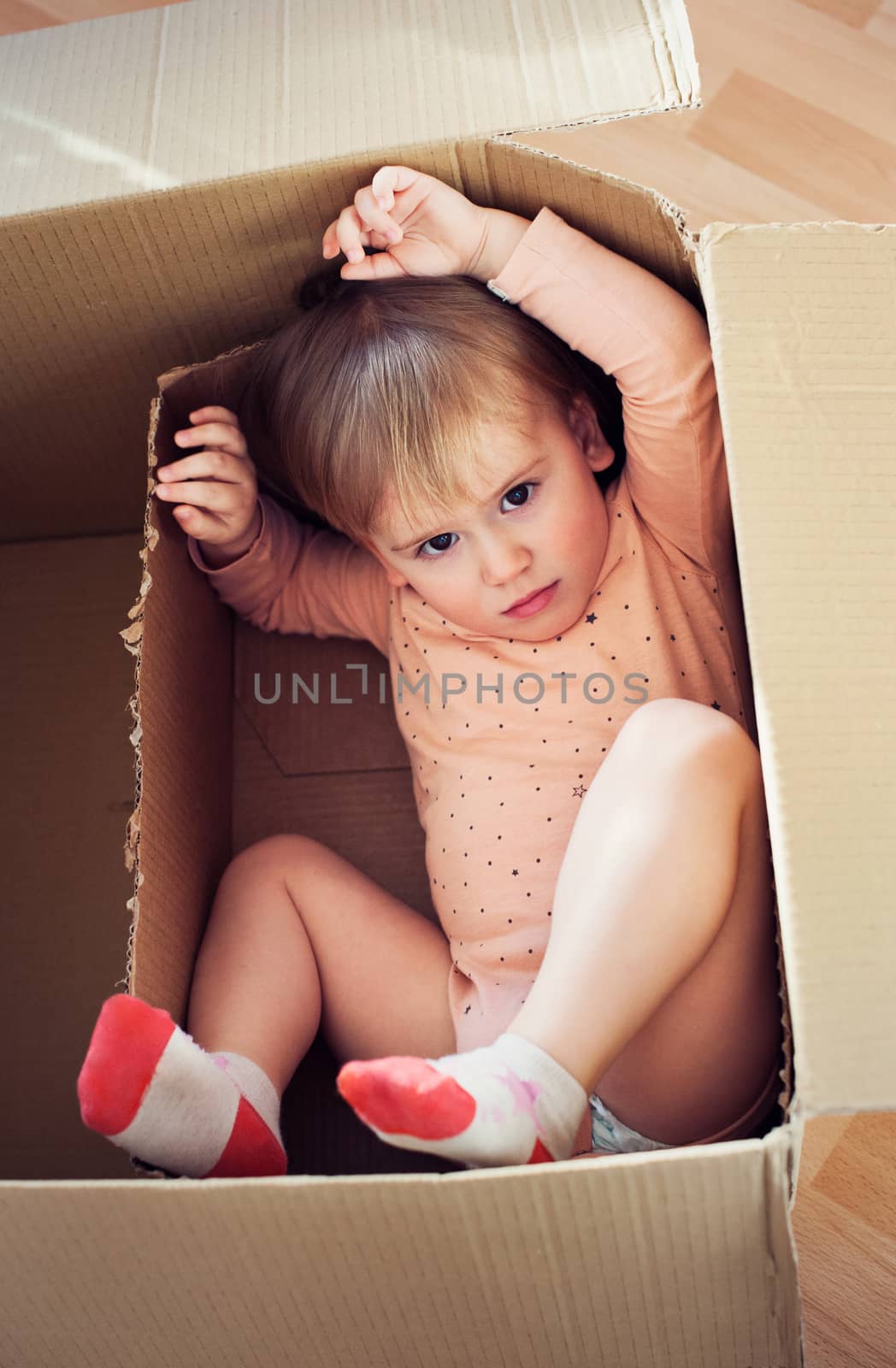 Baby toddler in a carton box having fun