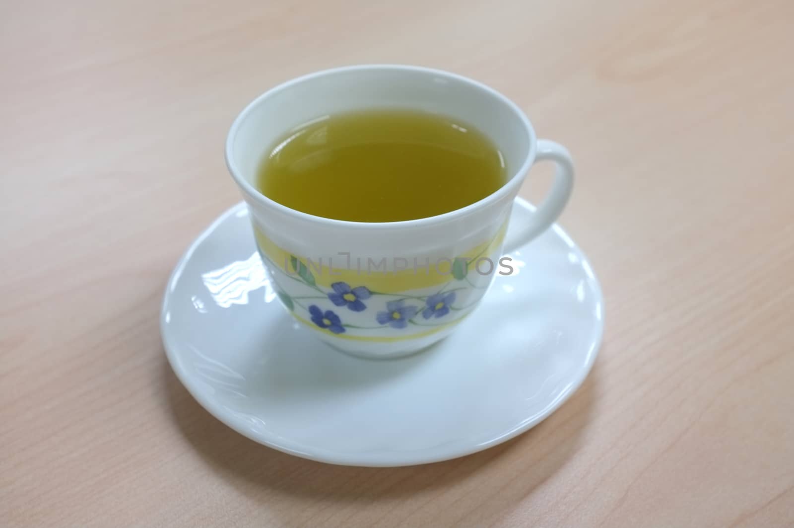 A white ceramic cup of green tea isolated on white background