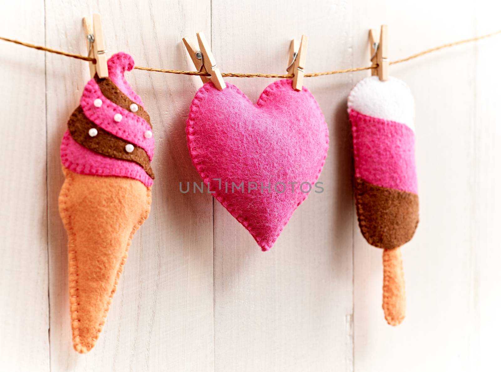 Love, Valentines Day. Heart and couple sweet ice cream, Handmade, hanging on rope. Vintage romantic style, white wooden background, toned. Vivid unusual creative greeting card, multicolored felt