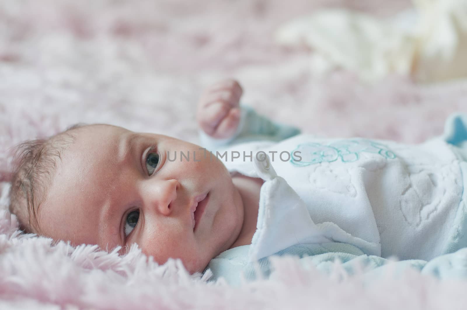 Laying Thoughtful baby indoor in blue cloth