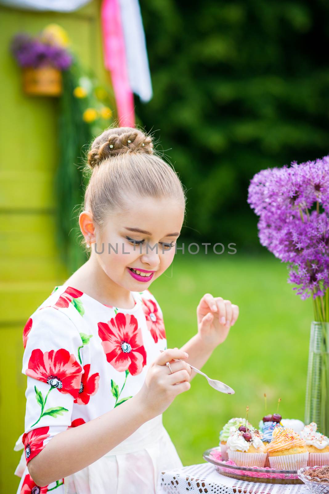 Girl decorating cupcakes in backyard by okskukuruza