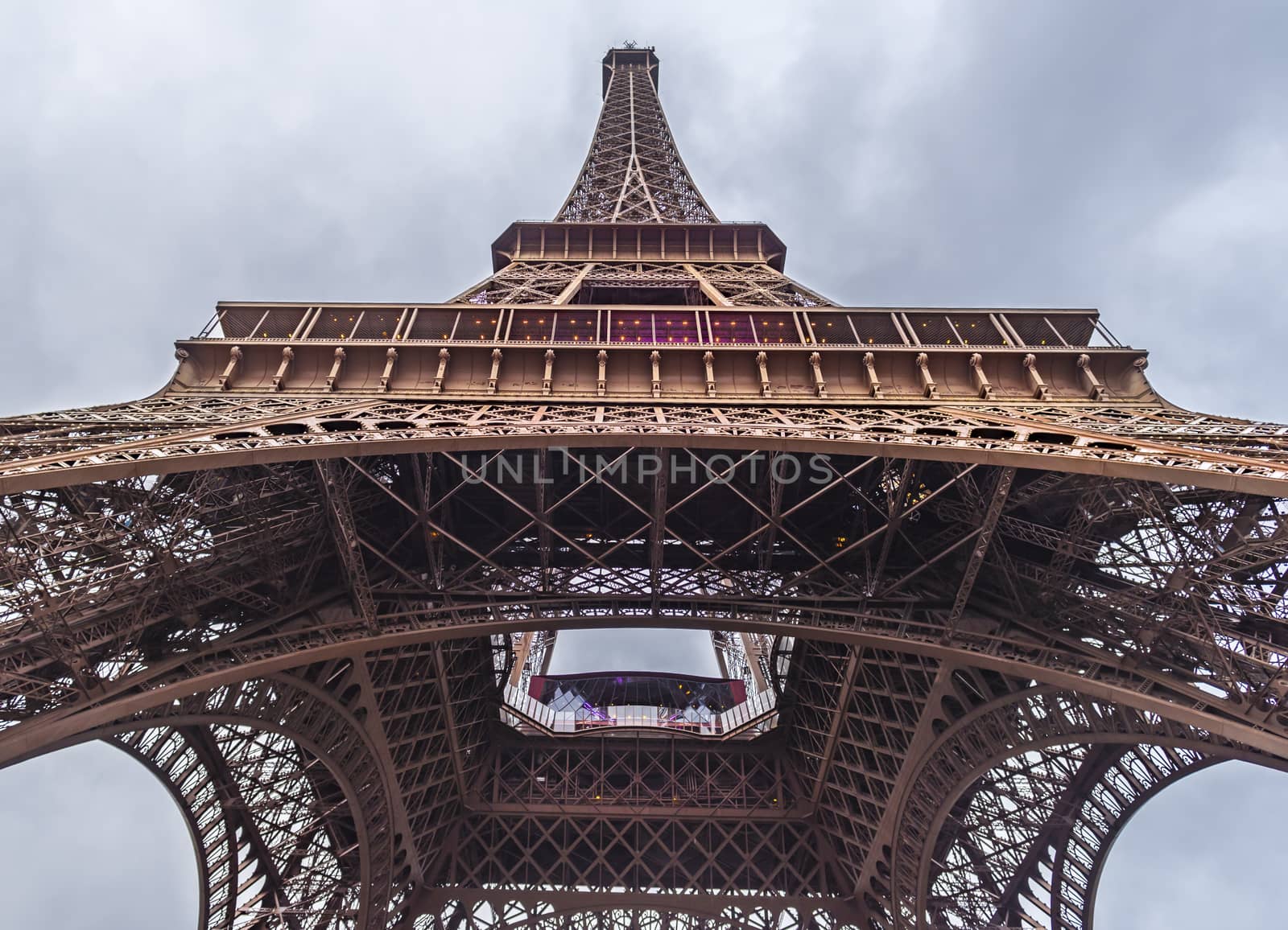 Beneath the Eiffel Tower image, from bottom to top, under a February blue sky . Picture taken in Paris, France.