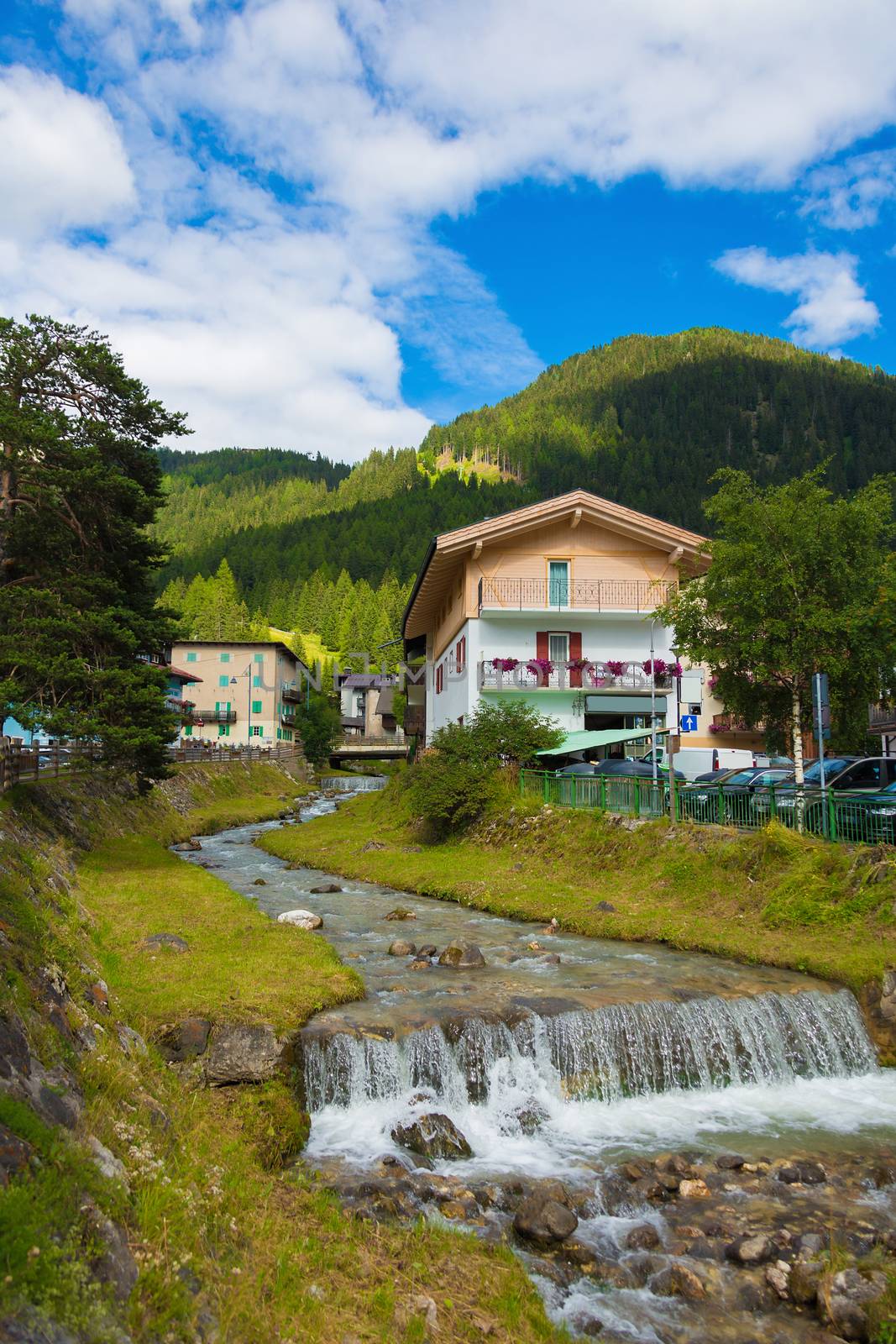 mountain river flowing through village in the Alps