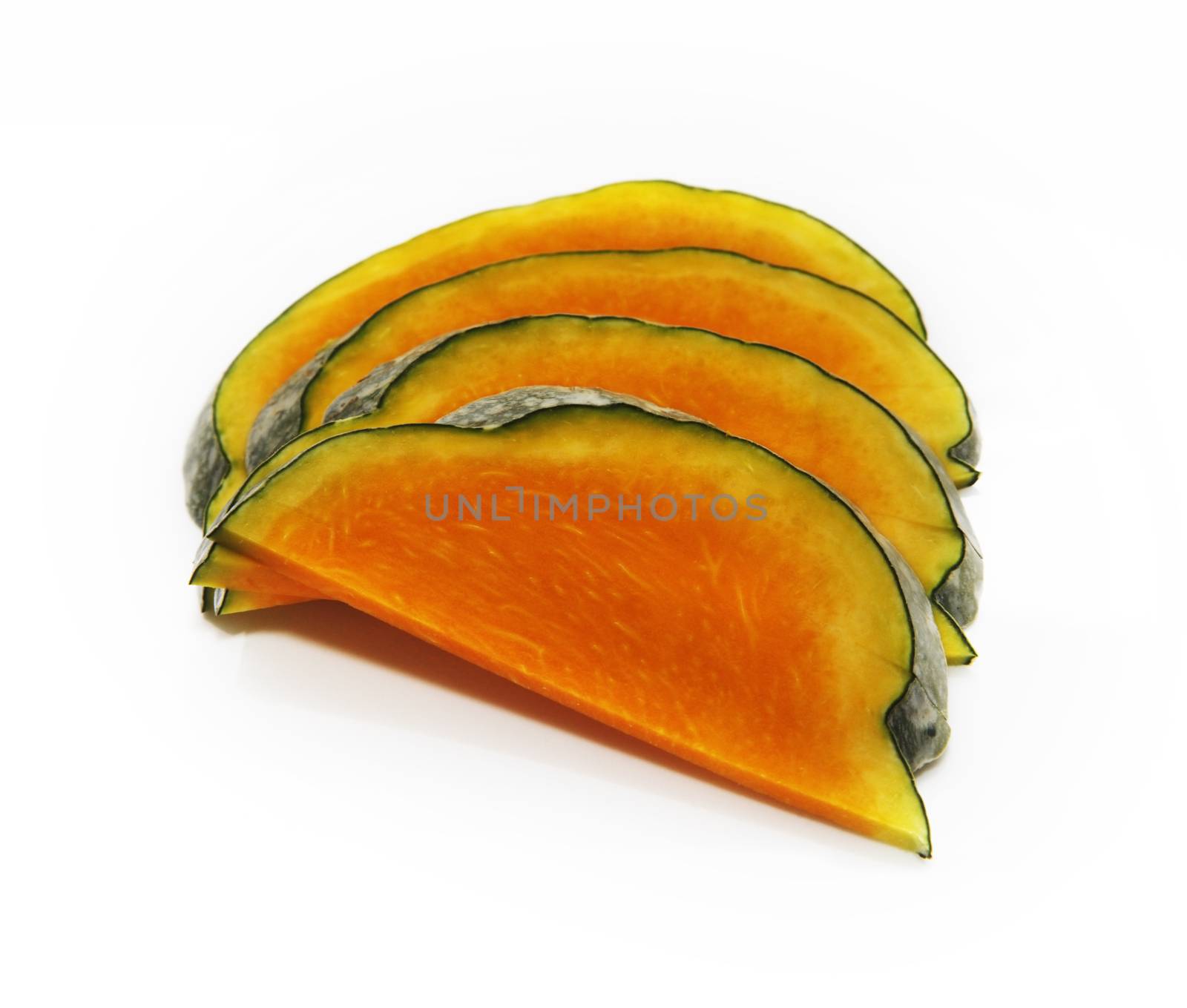 Four slices of honeydew pumpkin on a white background