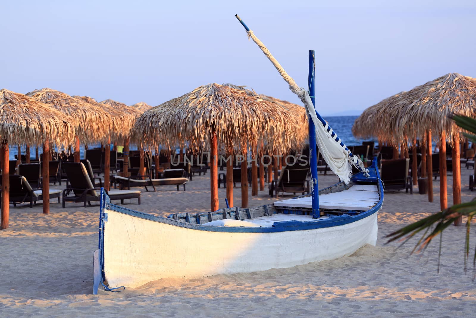 Wooden Boat With Straw Parasols in the Background. Beach of the Black Sea in Bulgaria