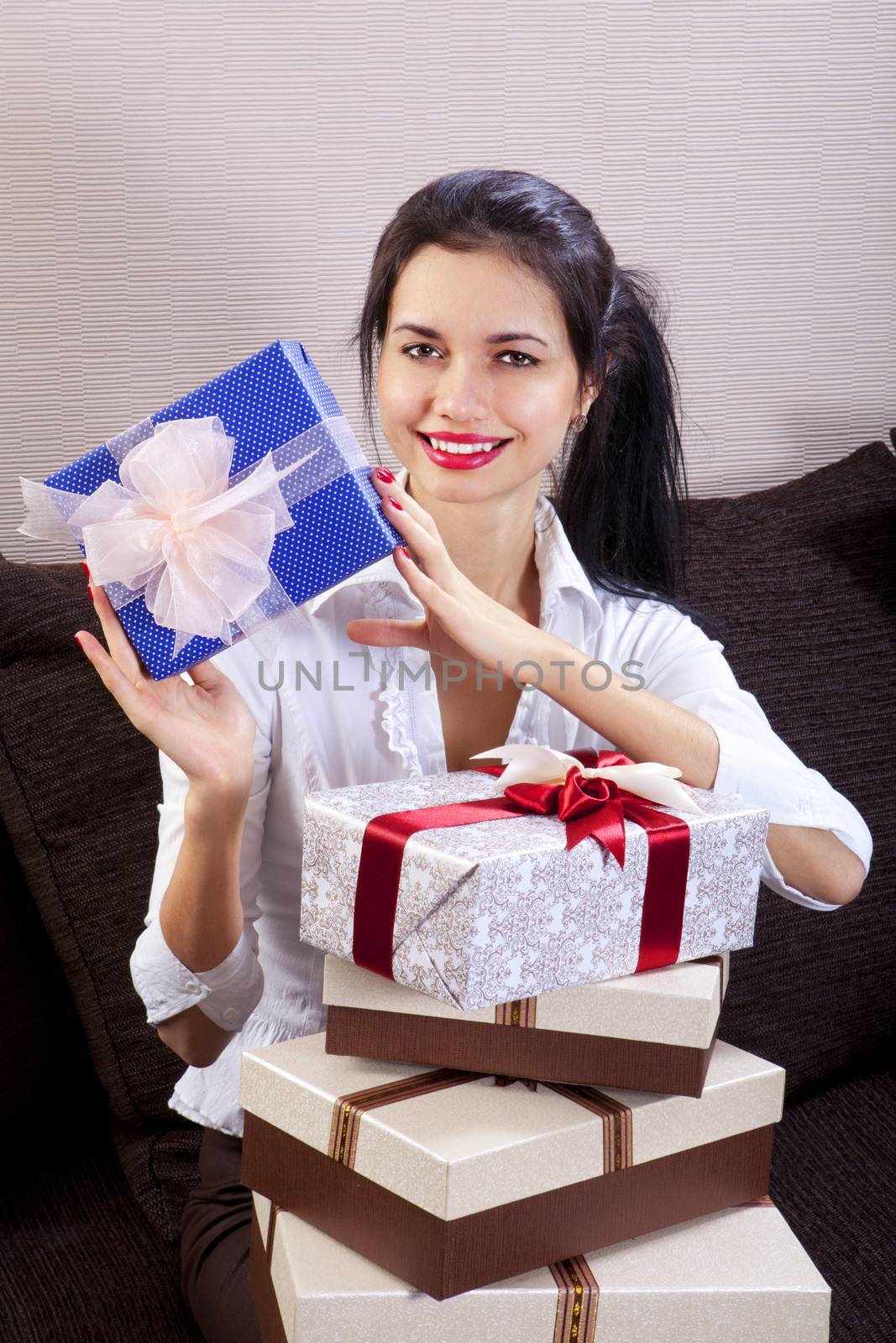 Young happy woman smiling and holds gift box in hands