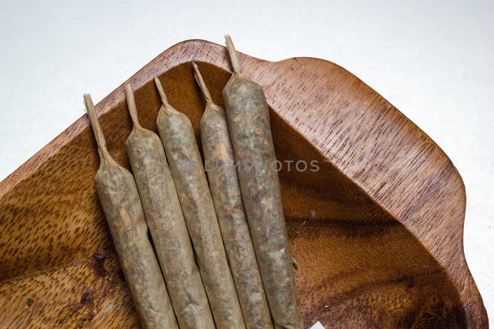 stock of hand made marijuana joints on wooden platter by johnqsbf