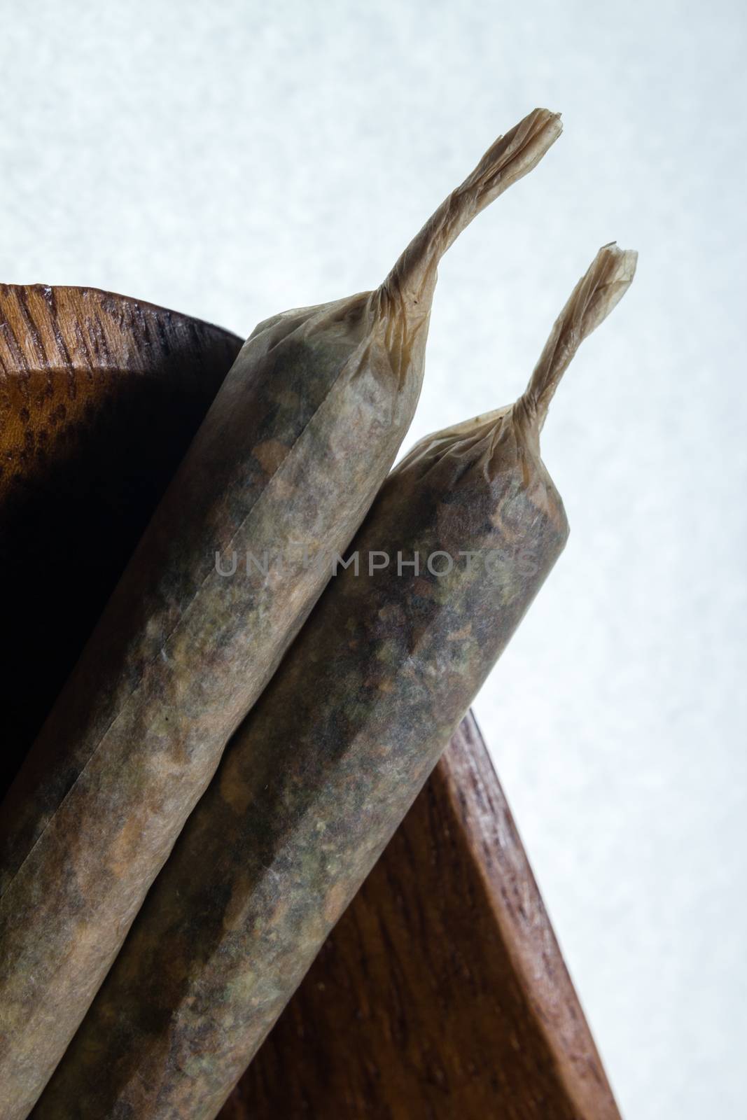 stock of hand made marijuana joints on wooden platter ashtray