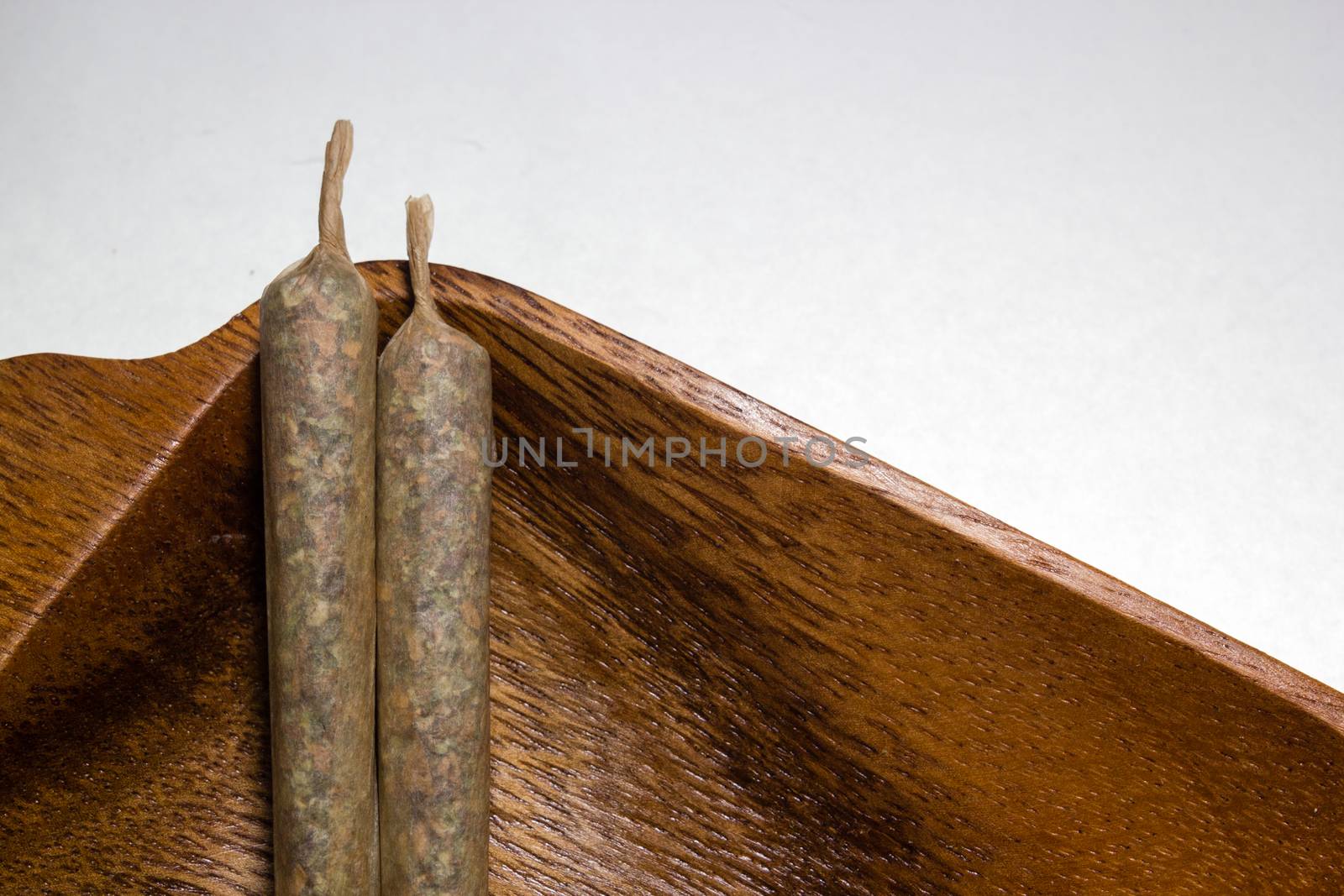 stock of hand made marijuana joints on wooden platter by johnqsbf