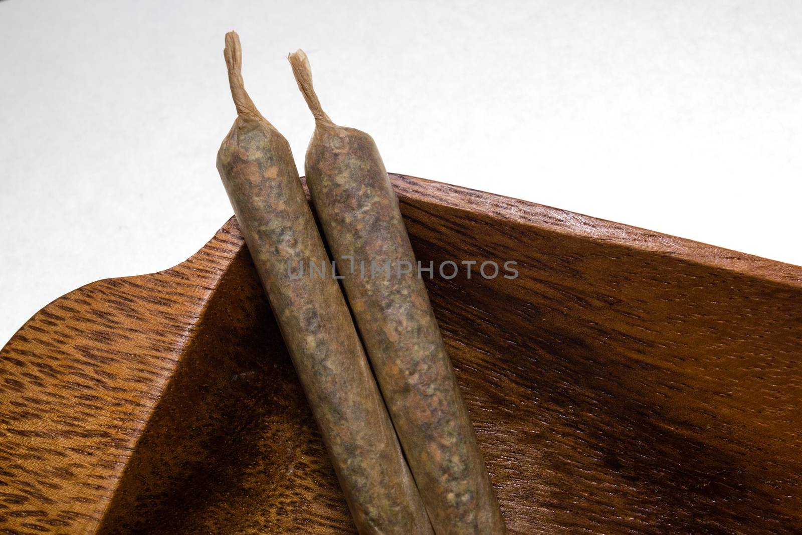 stock of hand made marijuana joints on wooden platter by johnqsbf