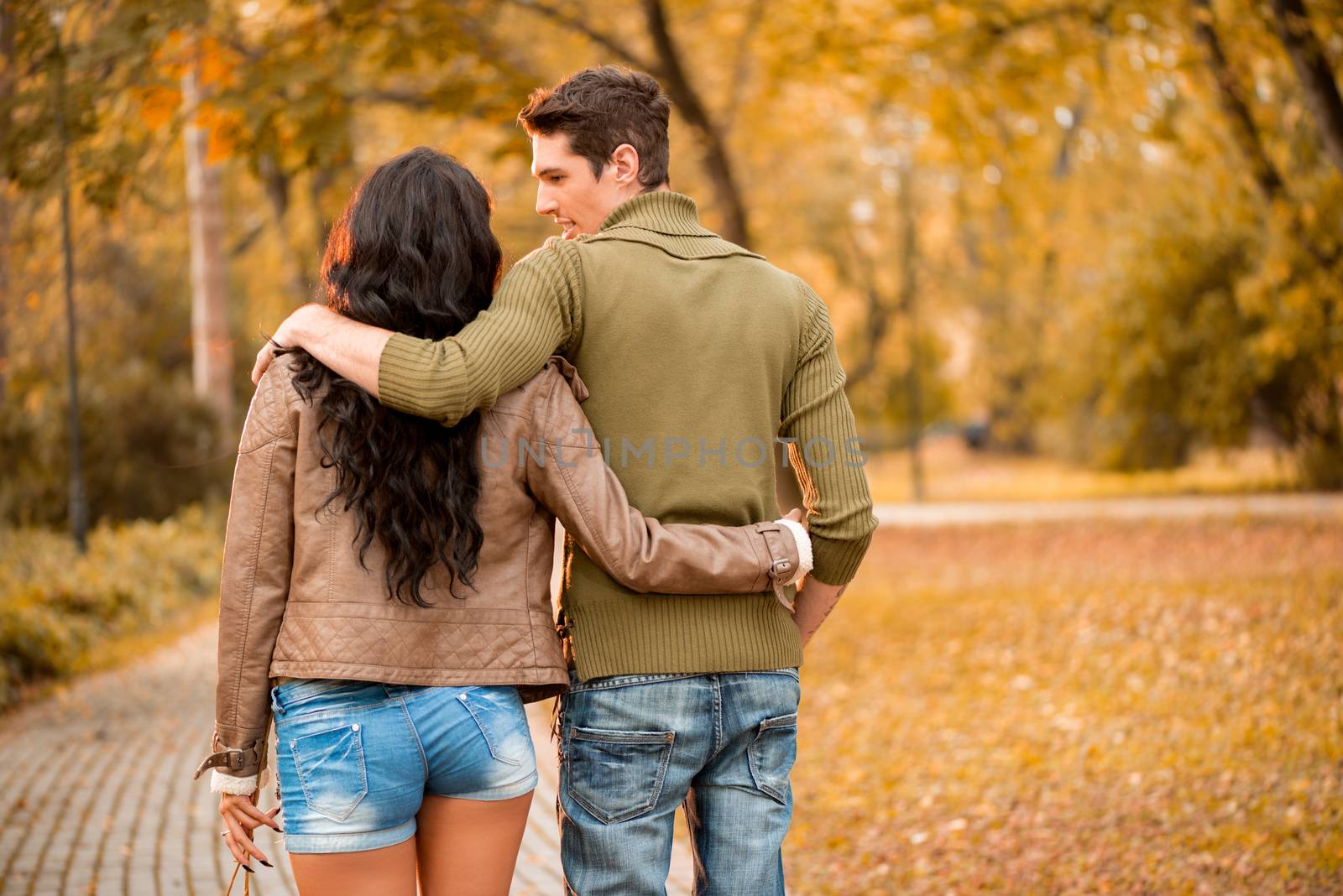 Loving young couple walking and enjoying autumn day in the park.