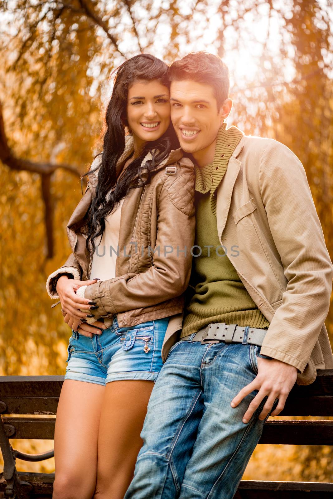 Smiling young couple enjoying autumn day in the park.