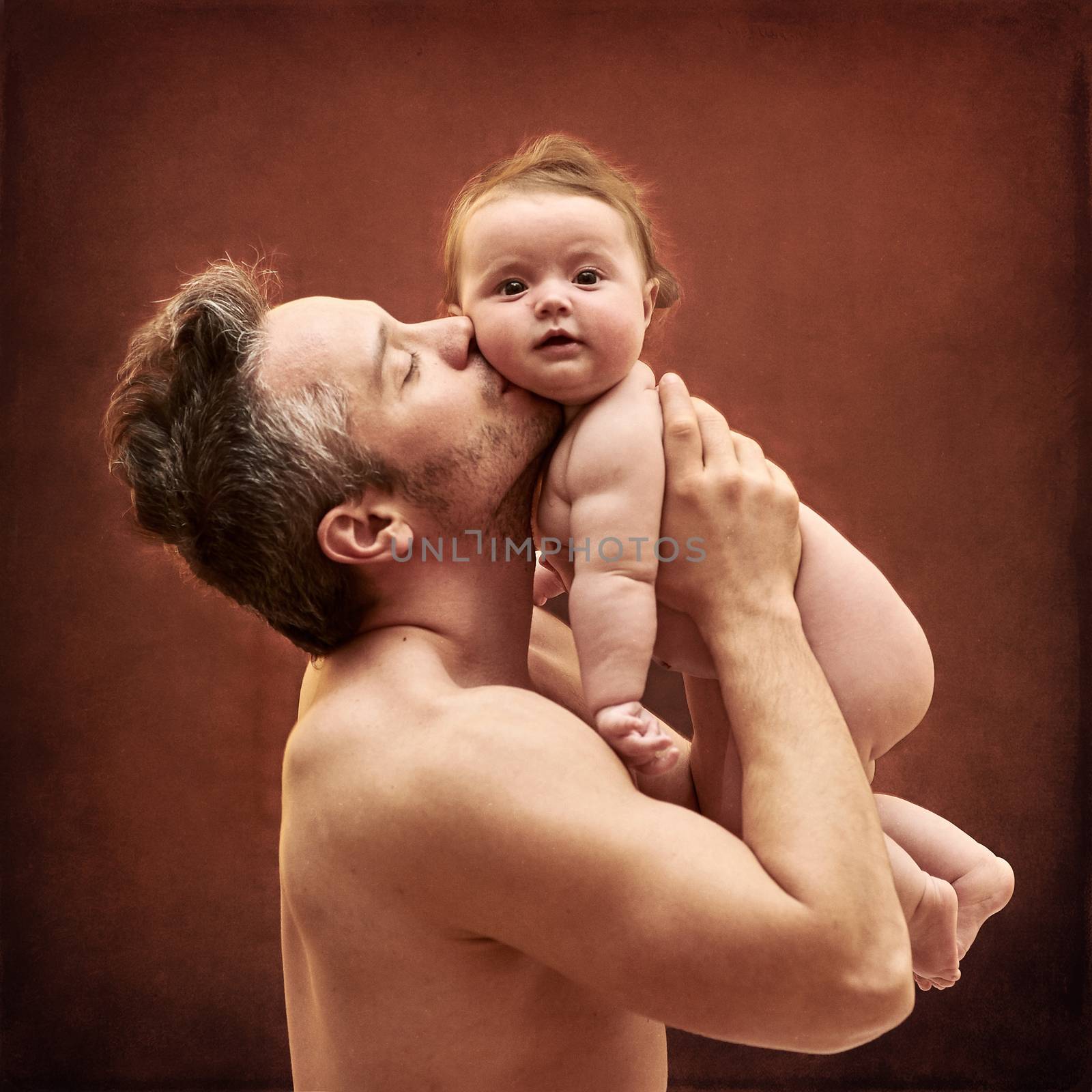 Dad Tenderly Holding a Child in Her Arms. by Multipedia