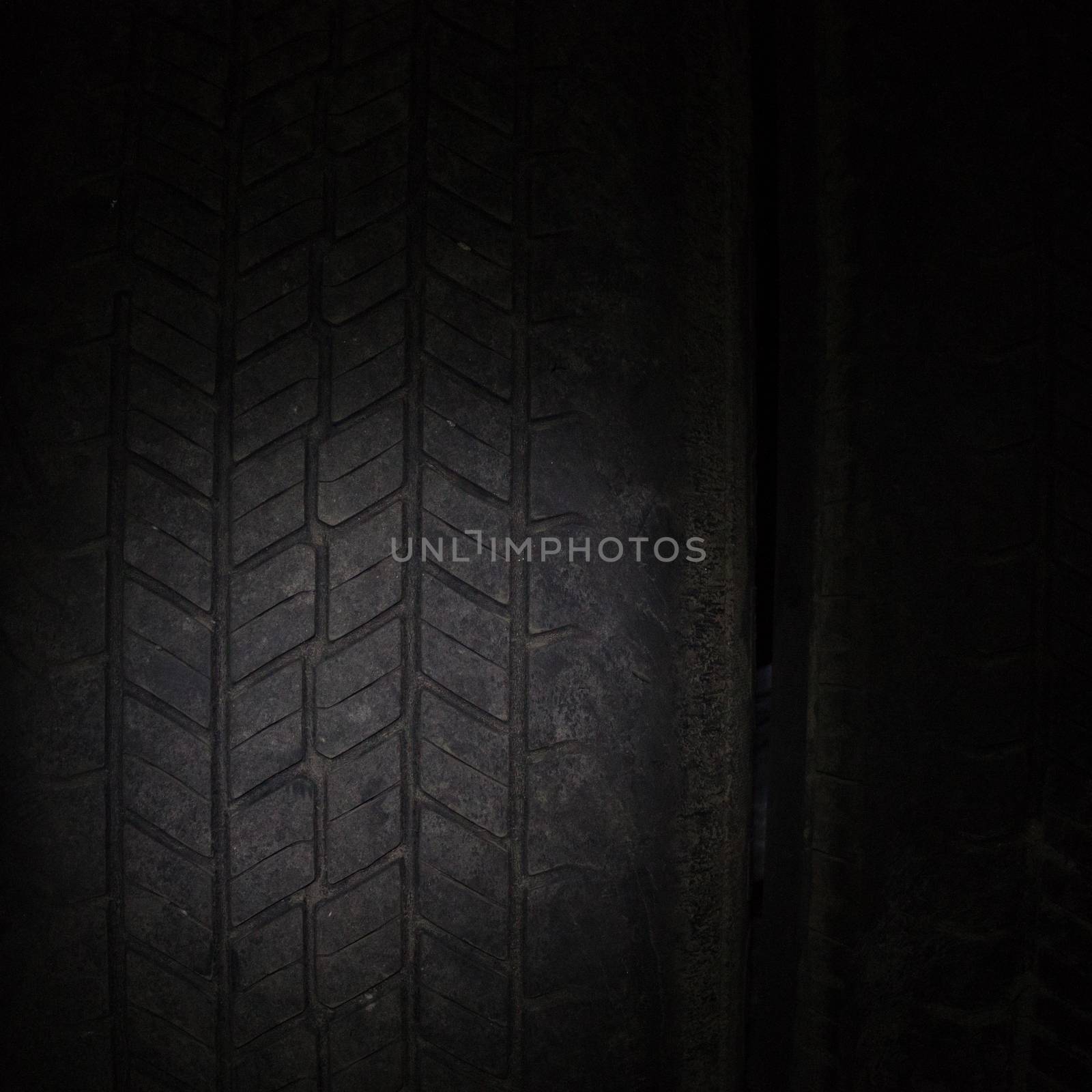 Car tires in a row on a shelf tire. Close-up in dark.