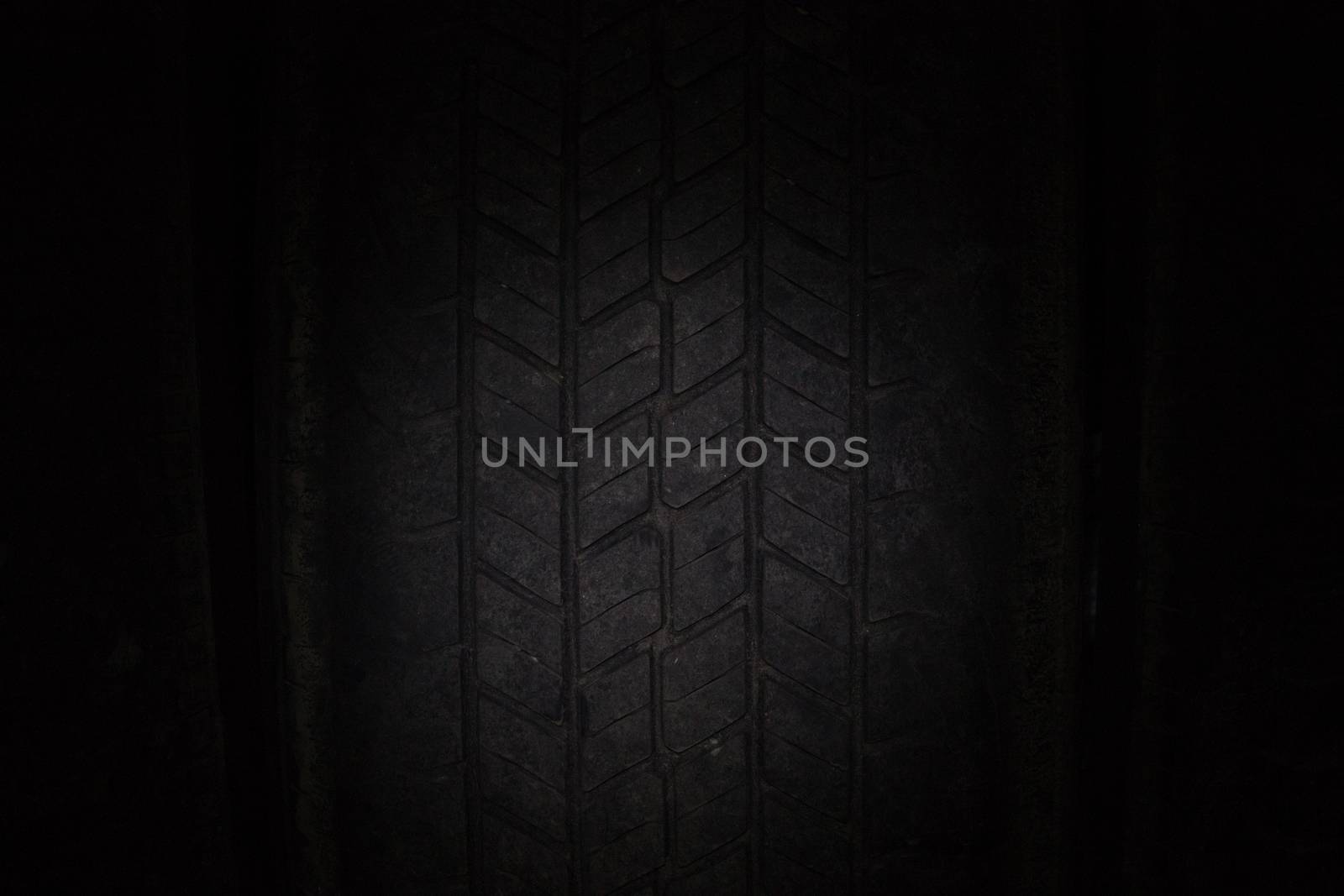 Car tires in a row on a shelf tire. Close-up in dark.