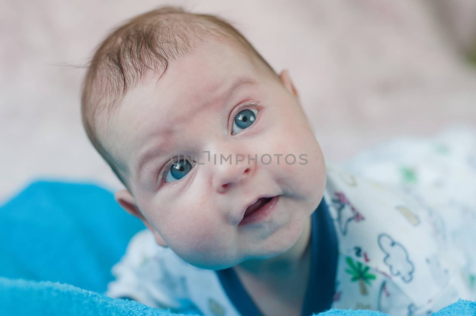 Little baby closeup portrait on the blue towel