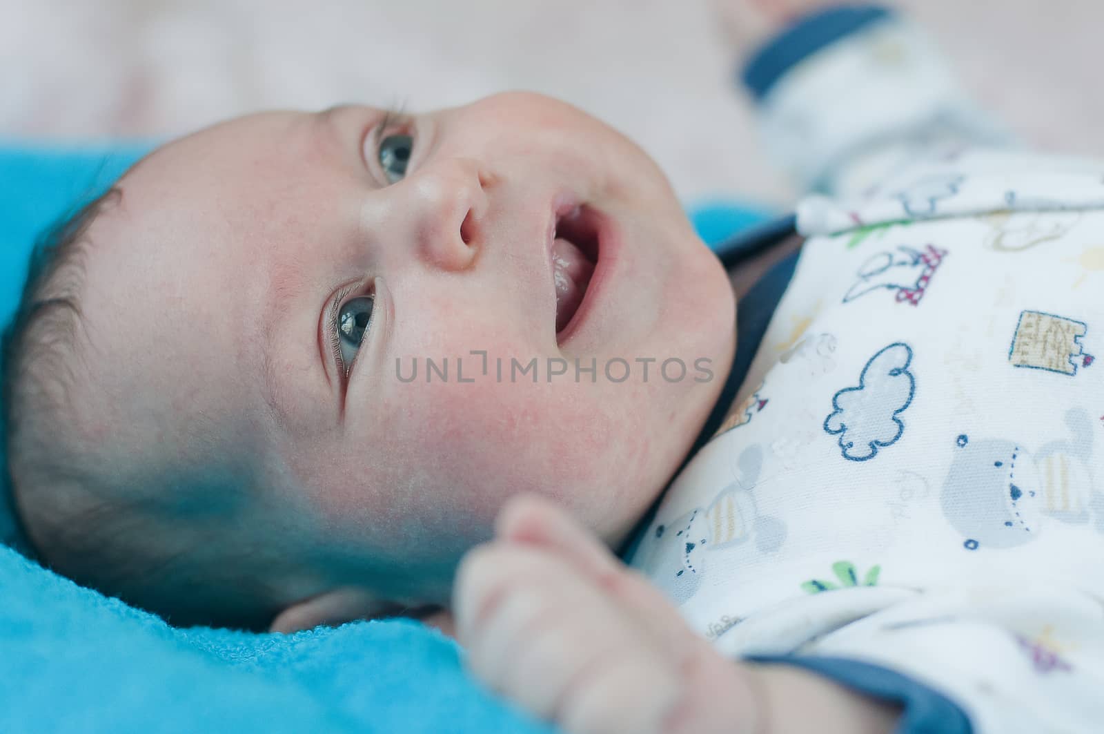Little baby closeup portrait on the blue towel