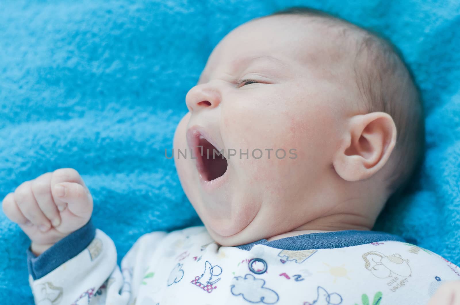 Little baby yawns on the blue towel by Linaga