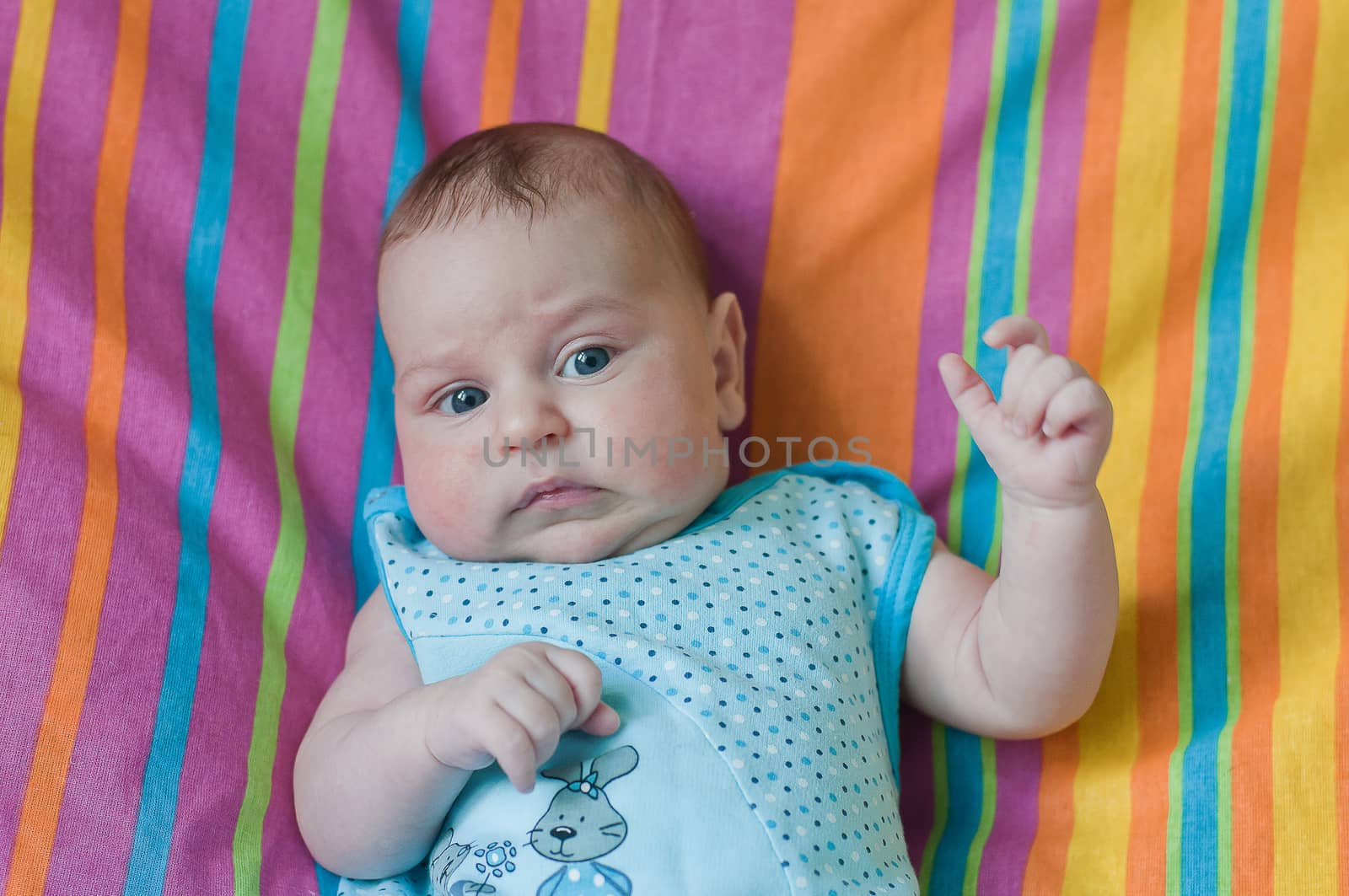 Little baby closeup portrait on the coloured towel