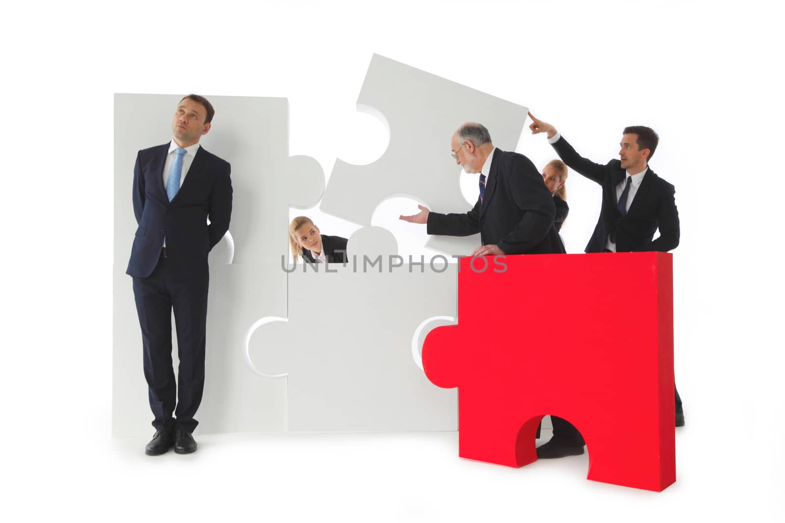 Group of business people assembling jigsaw puzzle isolated on white background