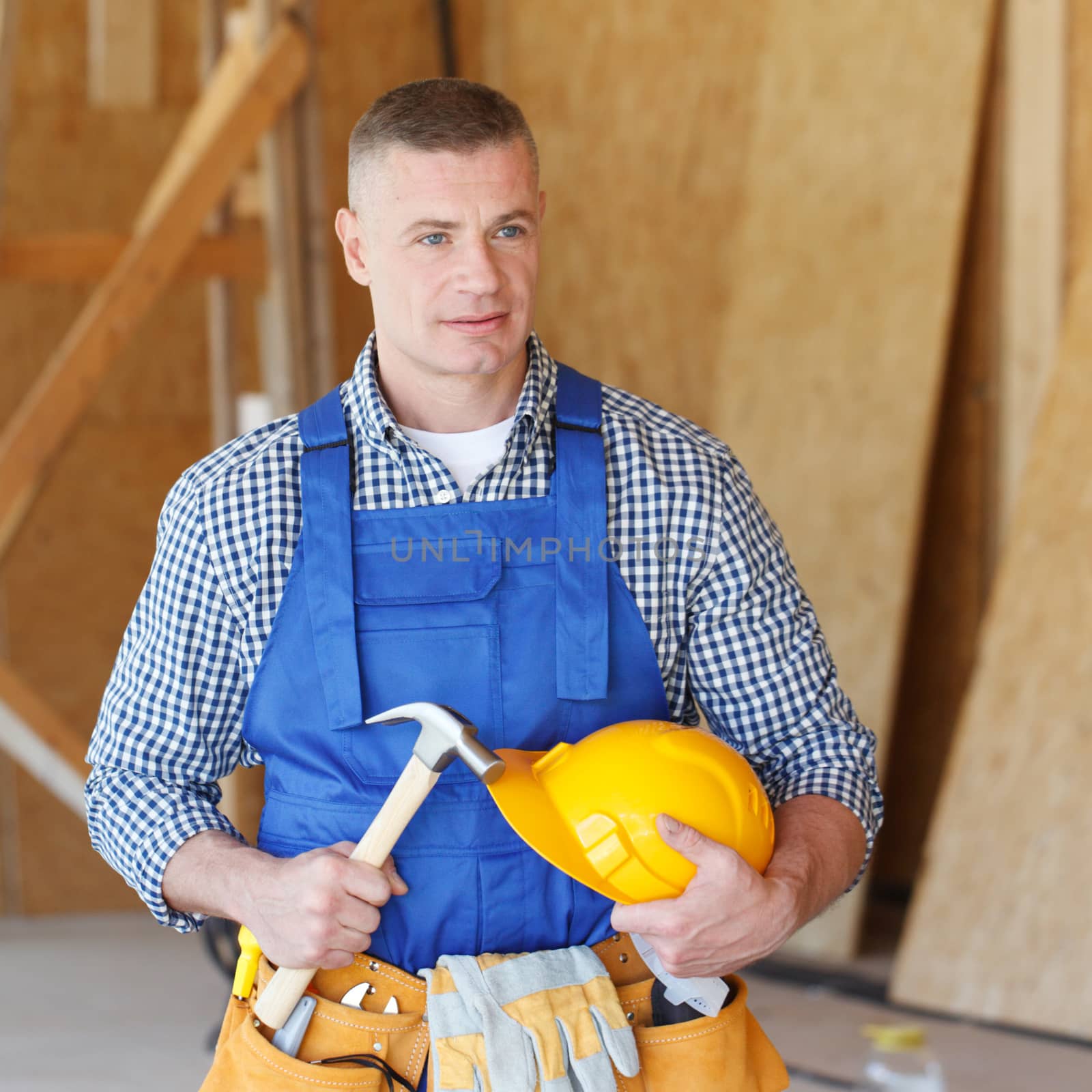 Construction worker with hammer in hand and tools at construction site