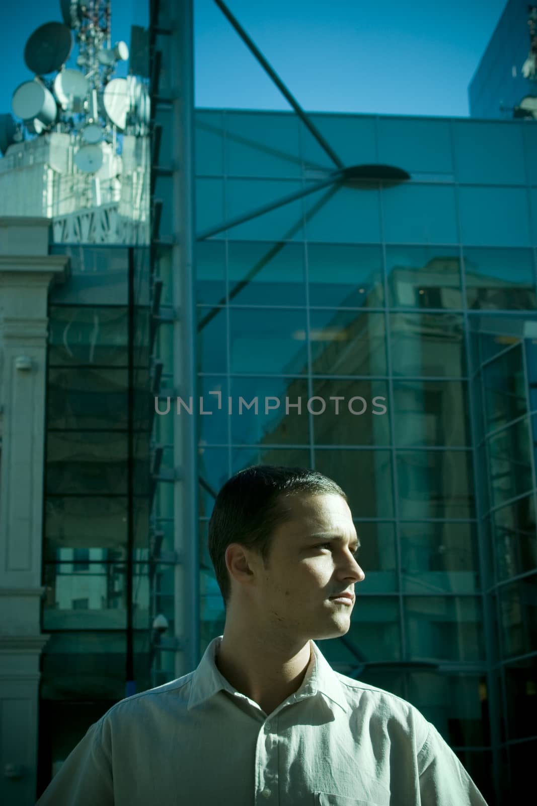 Young businessman in the telecommunications industry standing in front of an office building.