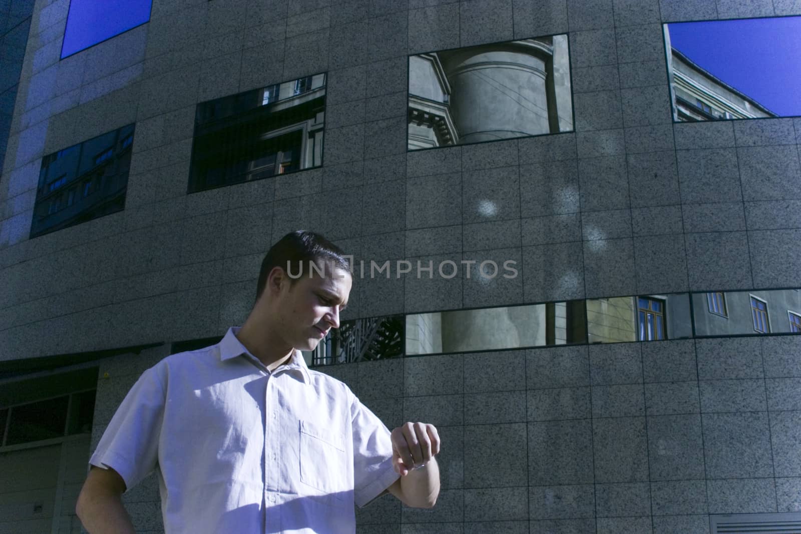 A young businessman checking the time as if he were in a rush.