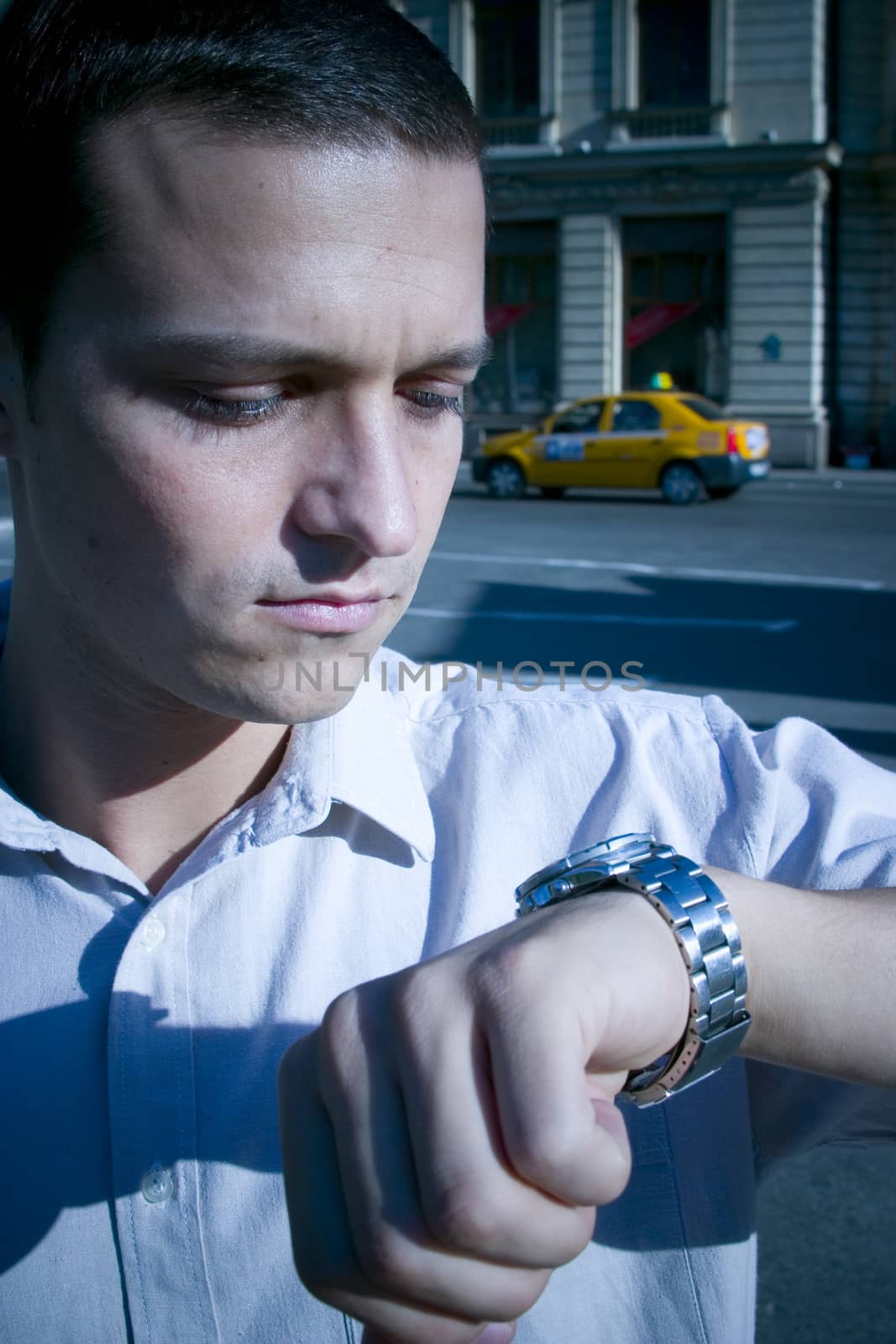 A young businessman with a deadline rushed for time, checking his watch.