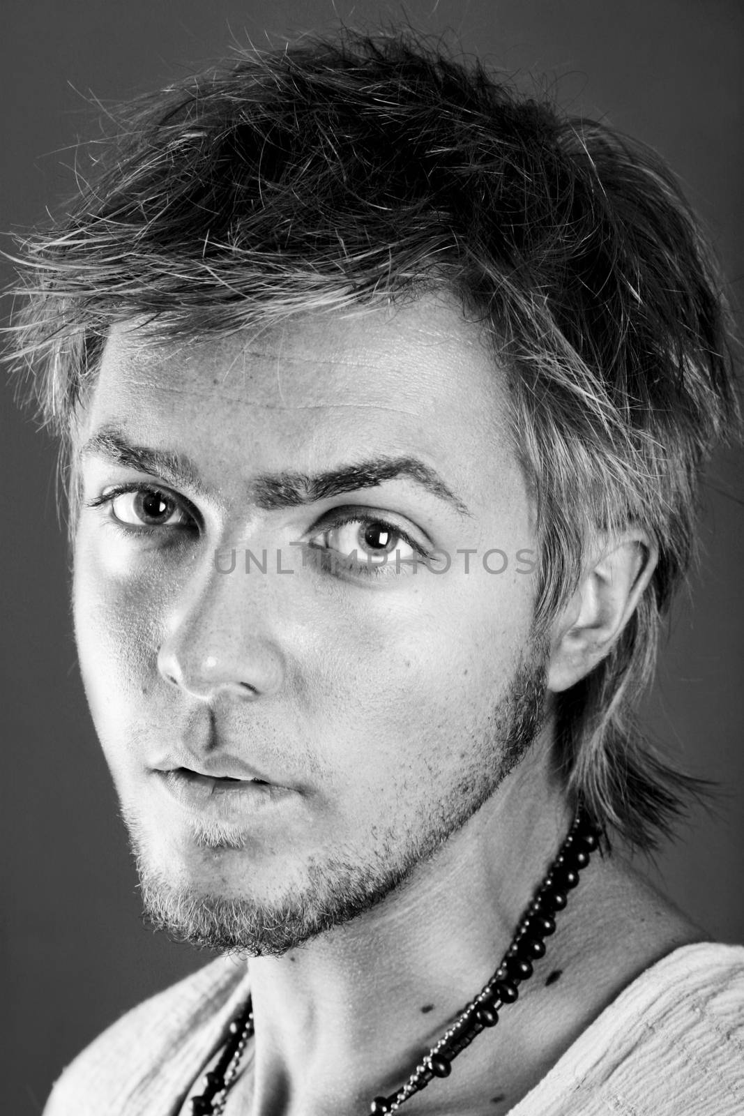 Black and white portrait of a young man with a serious look. Vertical orientation.