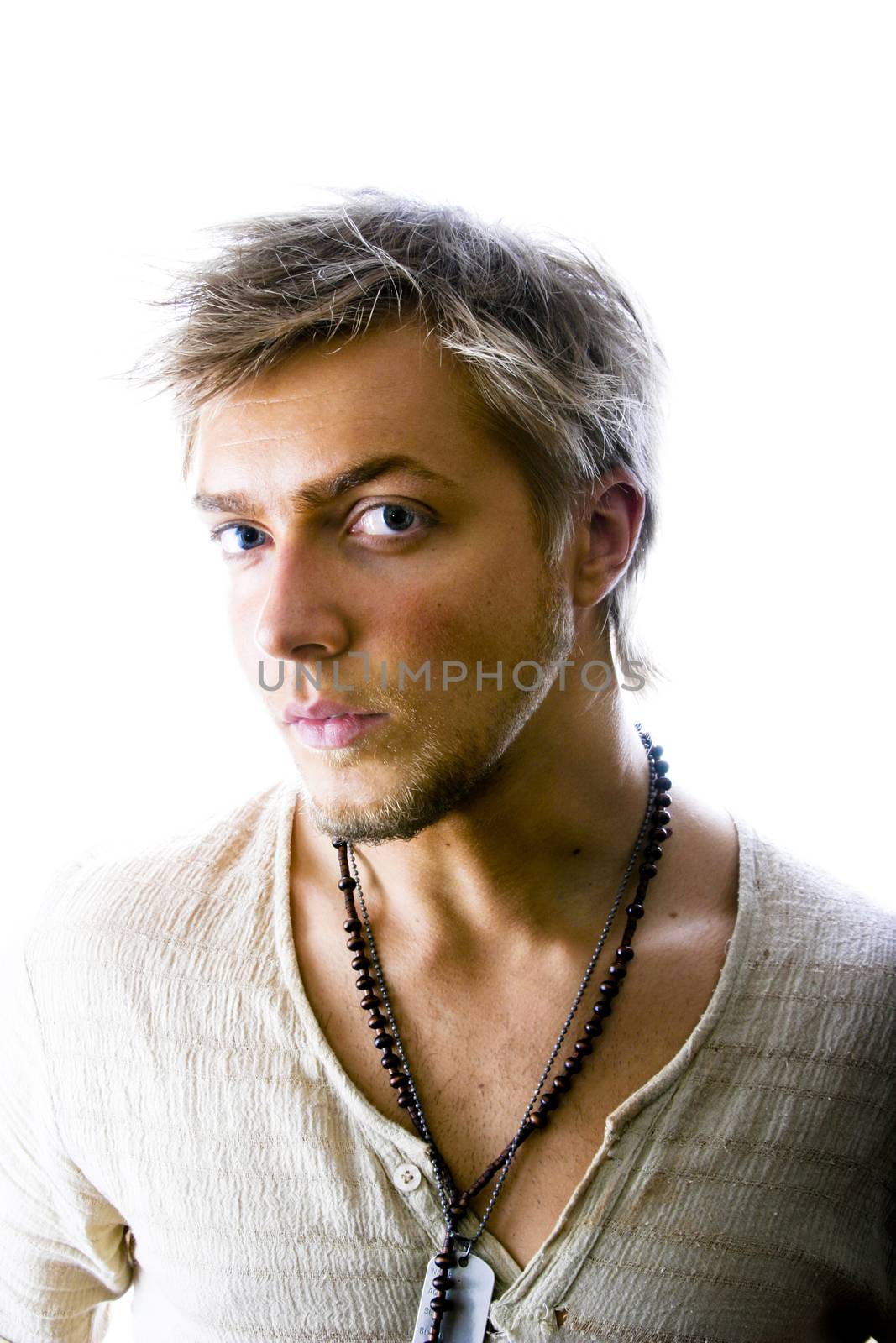 20 year old man with head turned slightly to the right, but eyes looking back toward camera suspiciously. Isolated on white background; taken in studio.