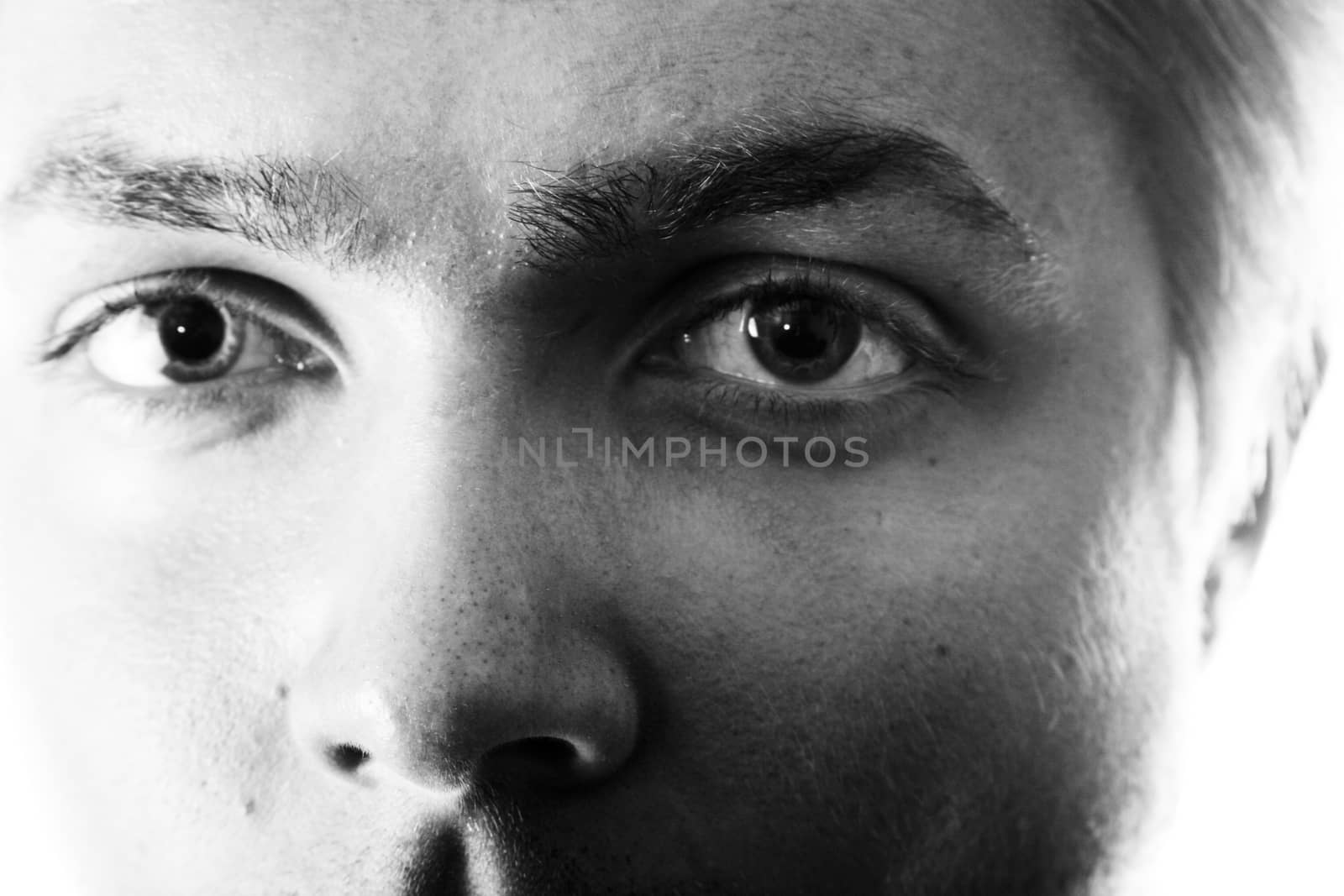 Black and white closeup of a young man's eyes staring