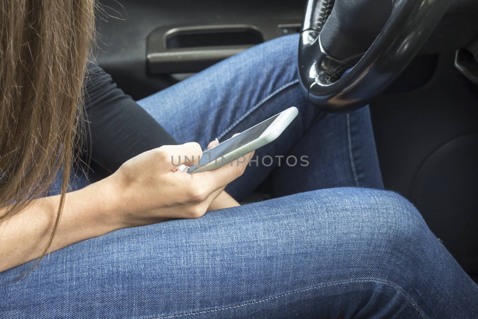 the girl picks up a text message on a mobile phone in the car