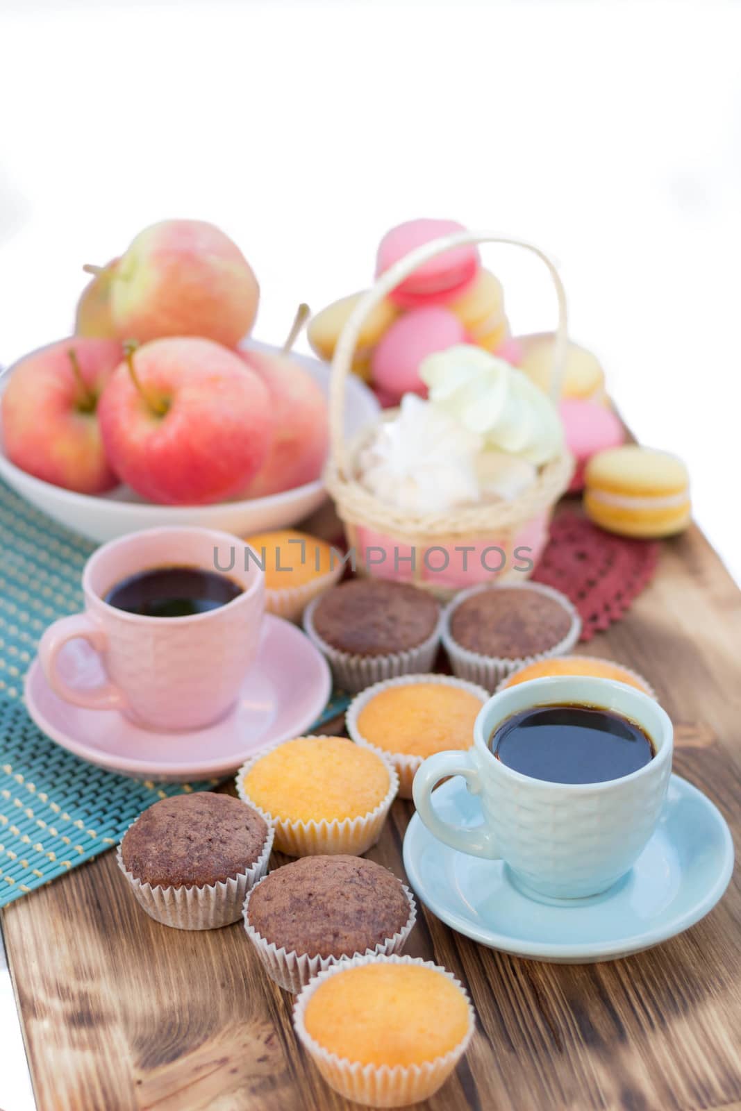 Still life of served coffee cups, macaroon cookies, marshmallows and apples