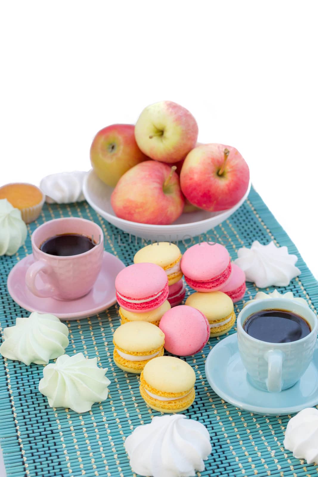 Still life of served coffee cups, macaroon cookies, marshmallows and apples