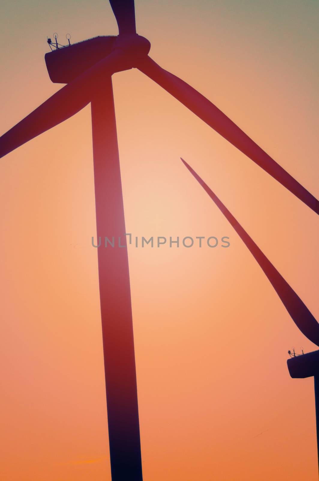 Wind turbine farm with rays of light at sunset