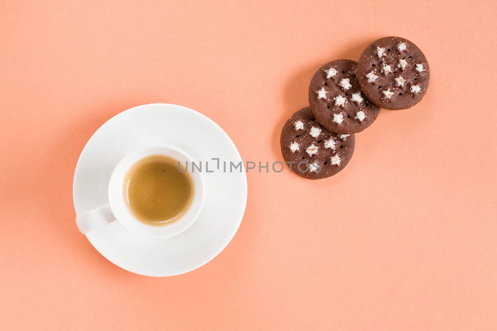 Italian espresso coffee and biscuits over a pink background seen from above