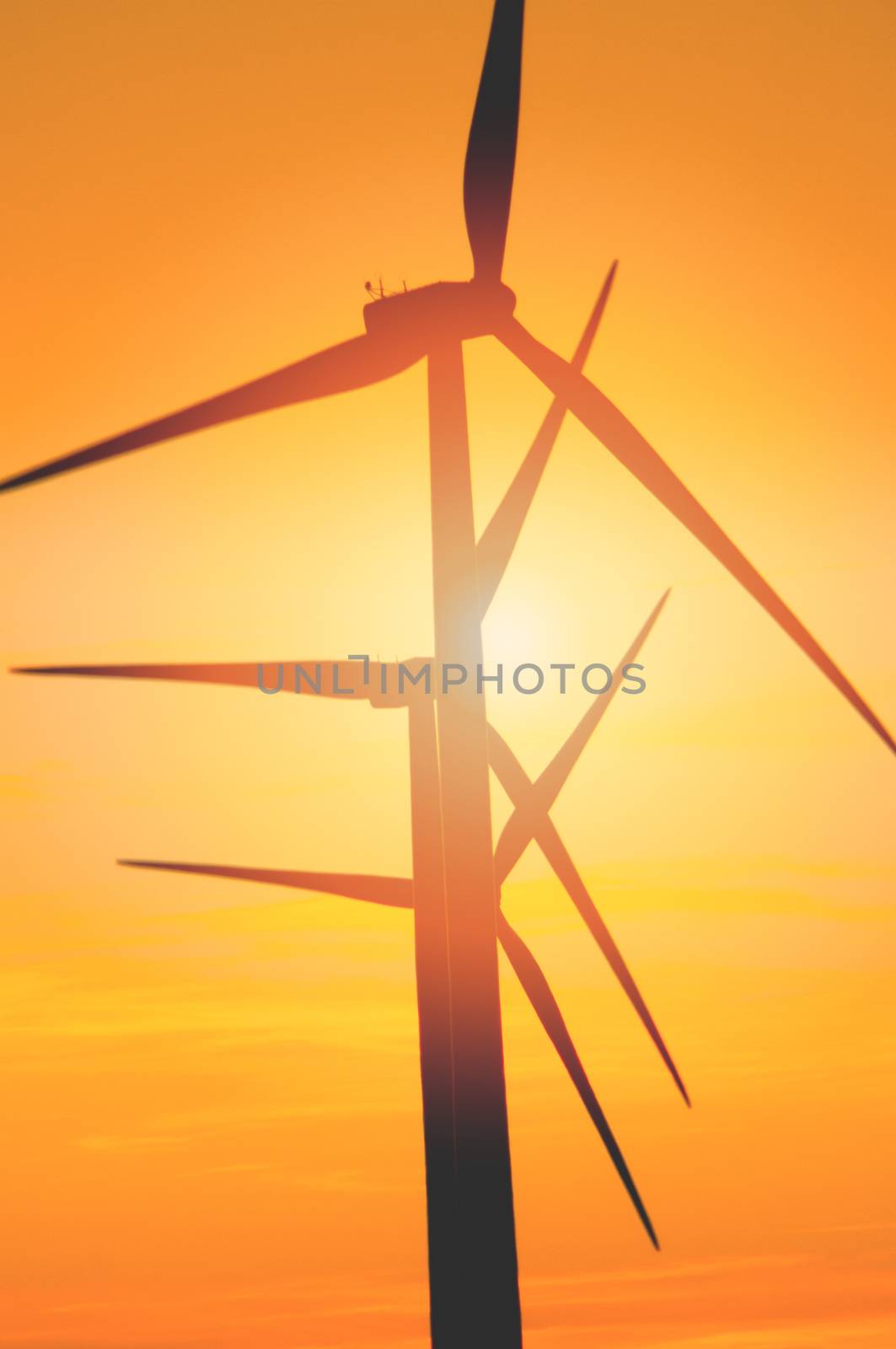 Wind turbine farm with rays of light at sunset