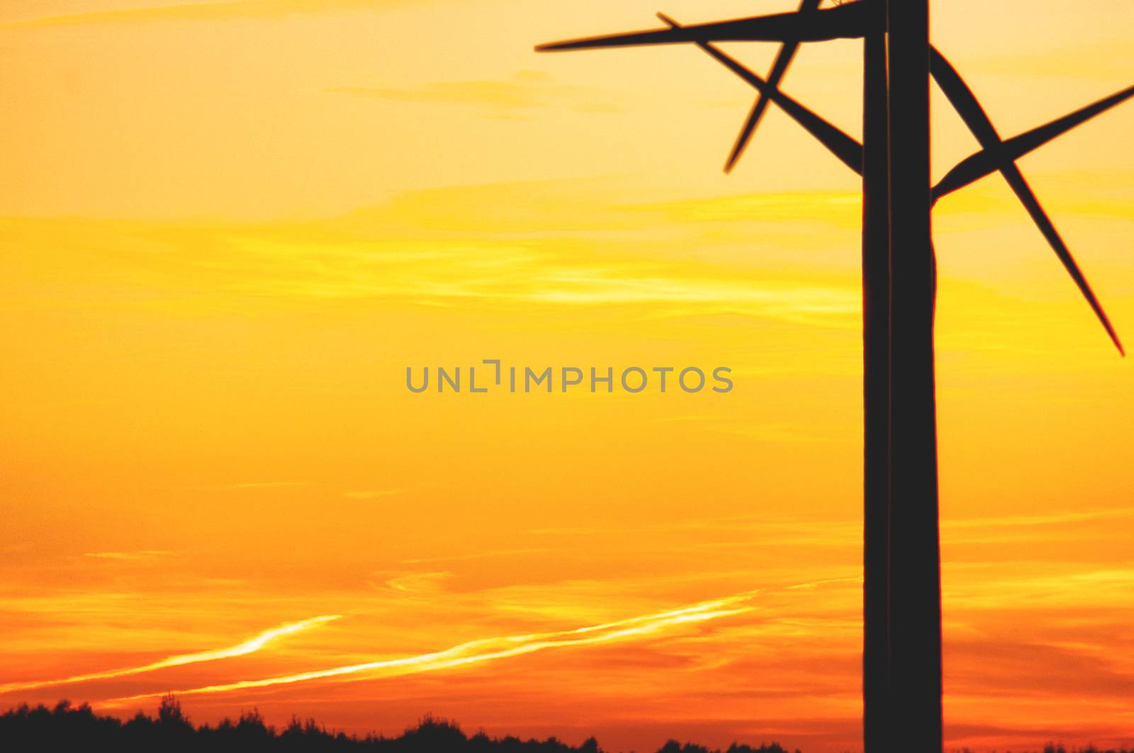 Wind turbine farm with rays of light at sunset